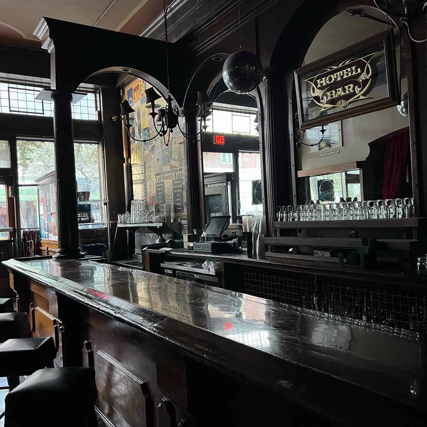 Photo of the Hotel Congress in Tuscon. It is dark and there is nobody at the bar. There is a sign that says "Hotel Bar" hanging up.