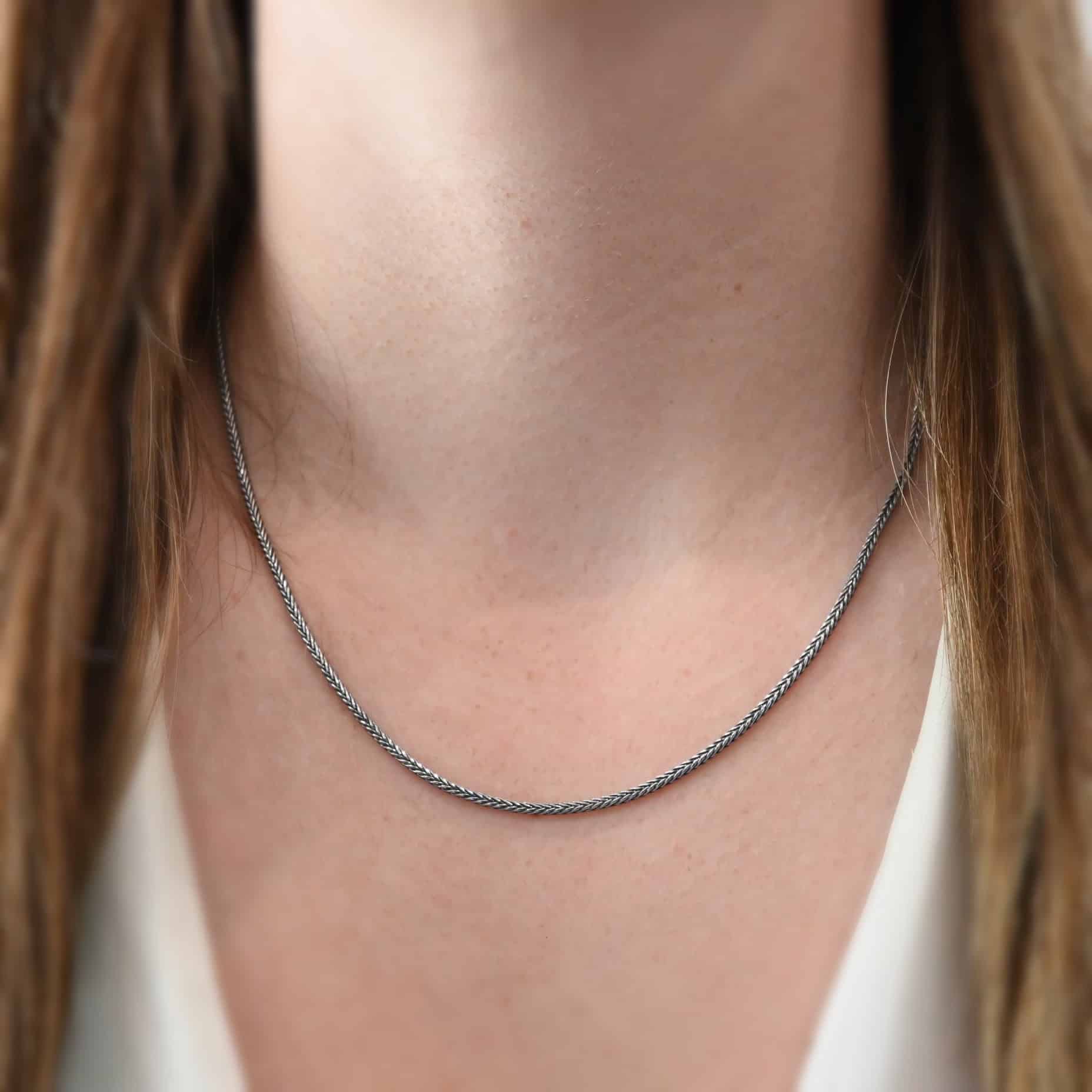 Close up of the "Snake Foxtail" Chain as shown on a model. Chain is shown at 18" long and oxidized. Chain is a 2mm foxtail chain.
