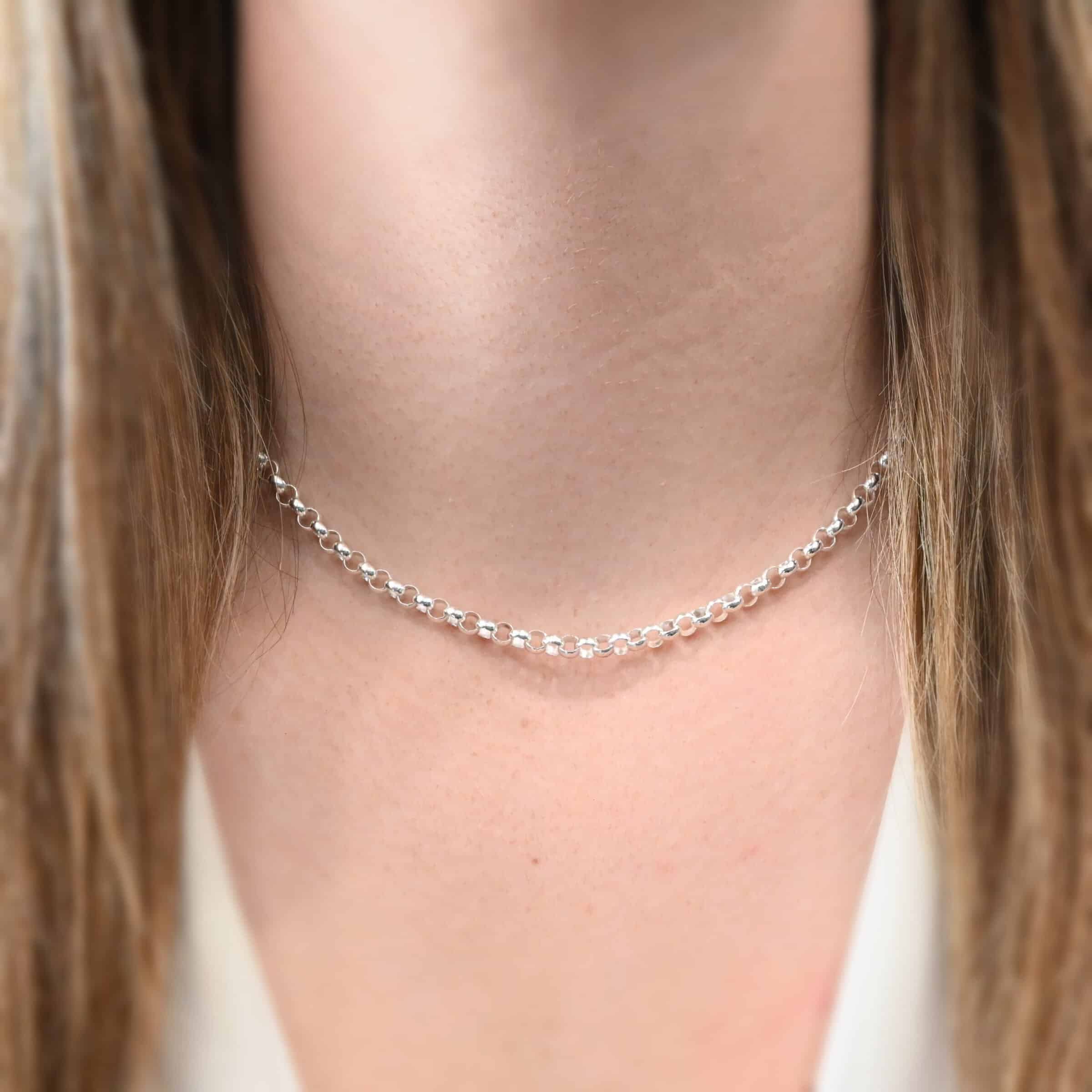 Close up of the "Roxy Rolo" Chain as shown on a model. Chain is shown as shiny and 16" long. Model is wearing a white v-neck shirt. Heavy Rolo links measure 4.25mm.