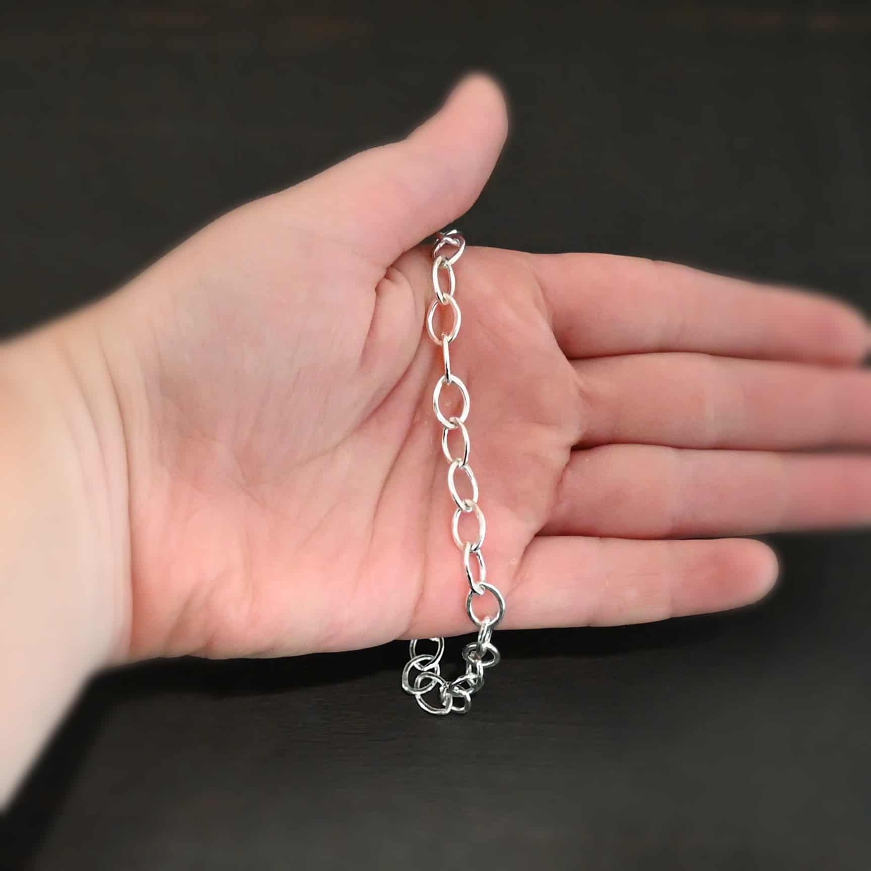 Sky Chain Hammered The "Sky" Chain. Shown as hammered, and shiny. Handmade links that are made out of sterling silver and connected to each other. Comes with a S hook clasp. Chain is laying against the palm of a hand to demonstrate size.