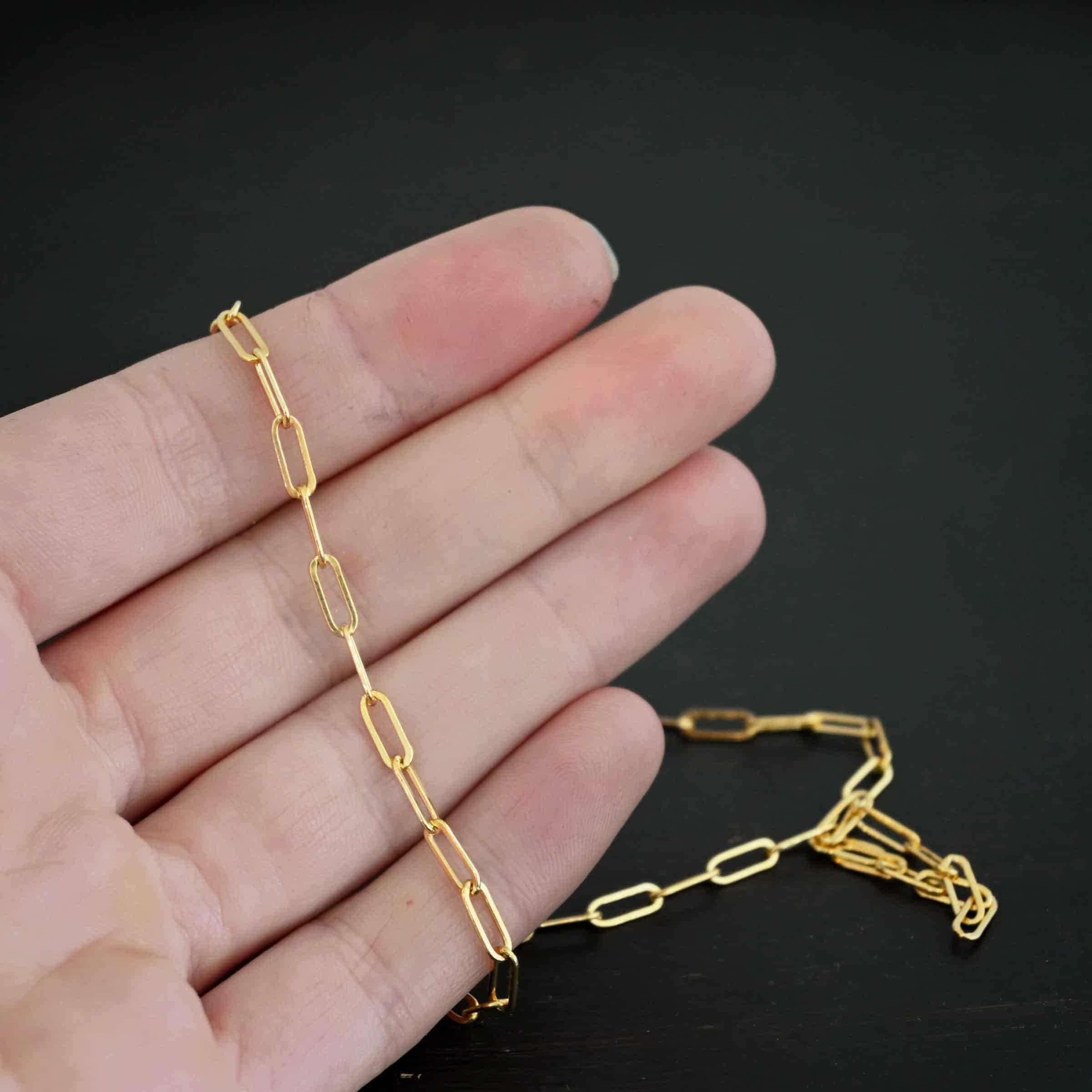 Lulu Link GF "Lulu Link" Chain as shown as gold filled. Links are 8.5x3x2mm. Chain is lying against the fingertips of a hand.