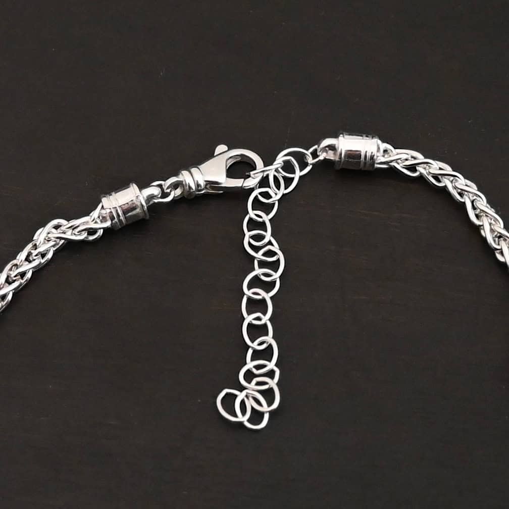King Cobra Wheat Chain The "King Cobra" Wheat Chain. Chain is handmade out of sterling silver and woven together loosely. Each link is woven to another one and there are sterling silver end caps on each end of the chain. Chain has a lobster claw clasp and comes with a 3 inch extension. Chain is laying against a dark background. Chain is shown as shiny. Lobster claw clasp is the main focus of the photo.