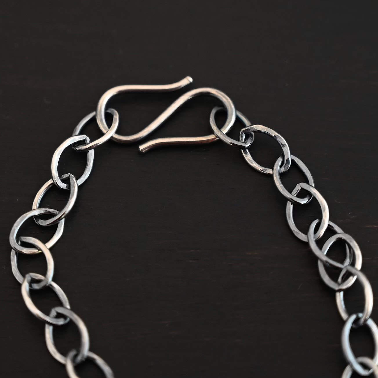 Sky Chain, Hammered, Oxidized Close up of the oxidized sterling silver Sky Chain that is made with large oval links that are hammered and connected together and there is an emphasis on the chain