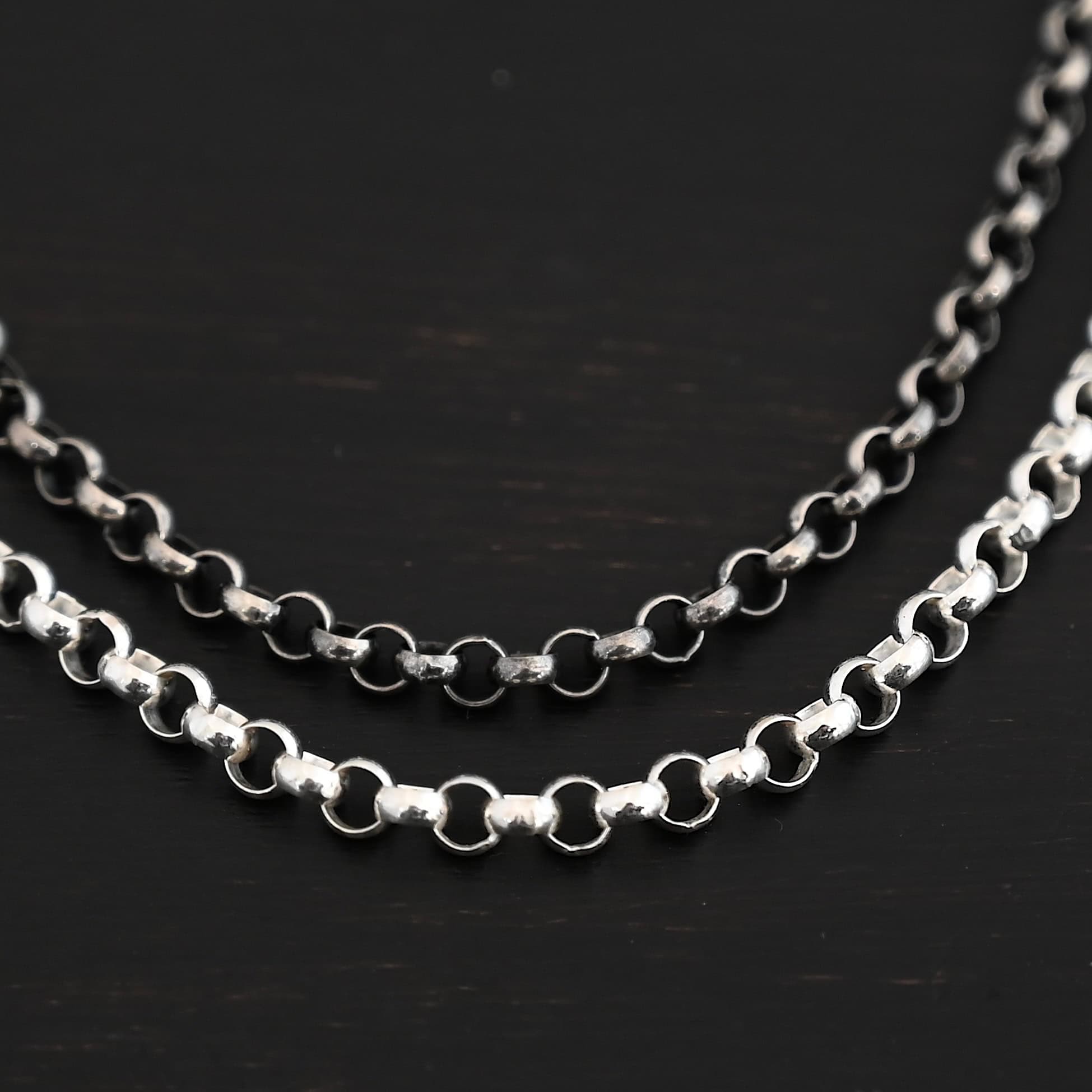 Close up of the shiny & oxidized sterling silver Roxy Rolo Chain that is made with small circular links all connected together