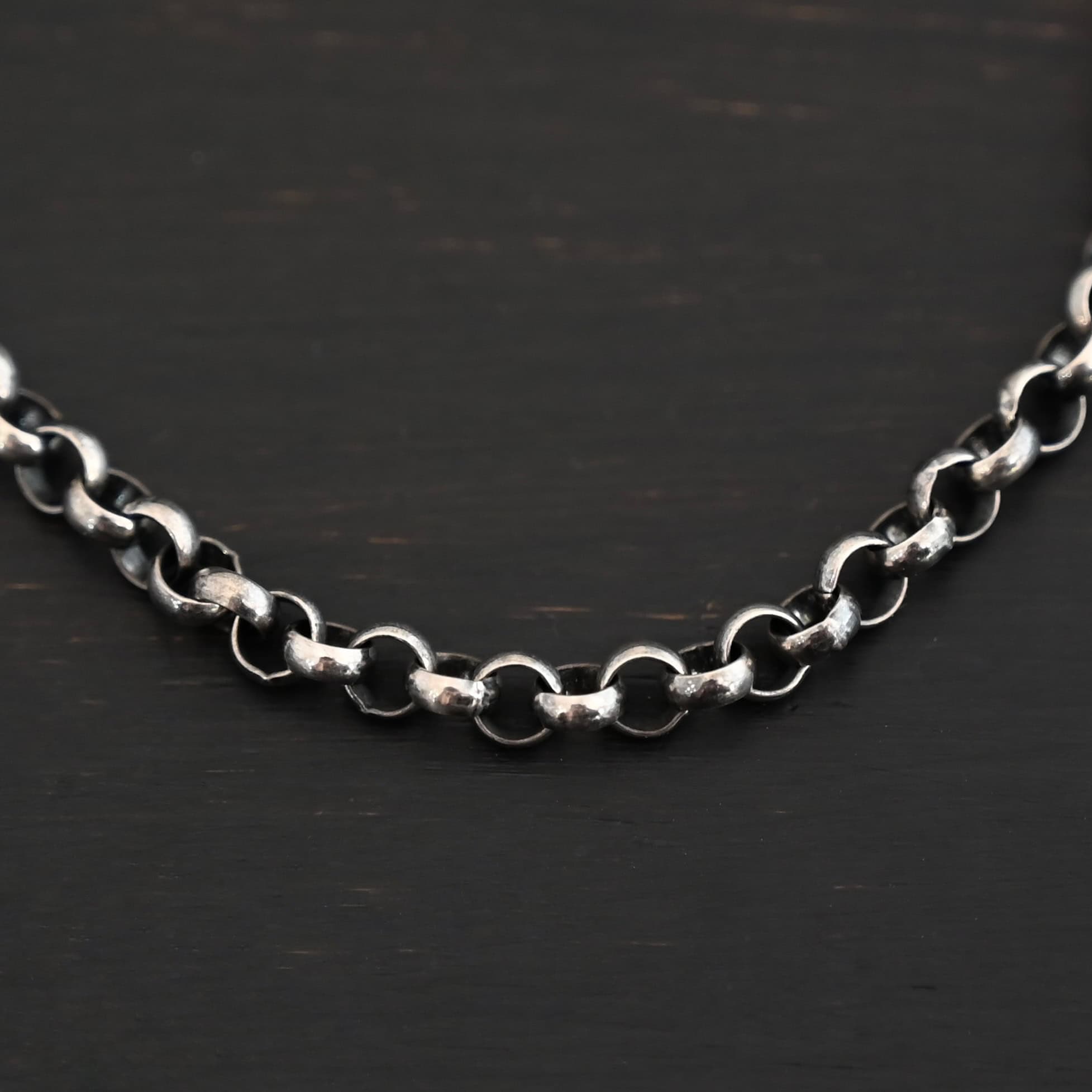 Close up of the oxidized sterling silver Roxy Rolo Chain that is made with small circular links all connected together
