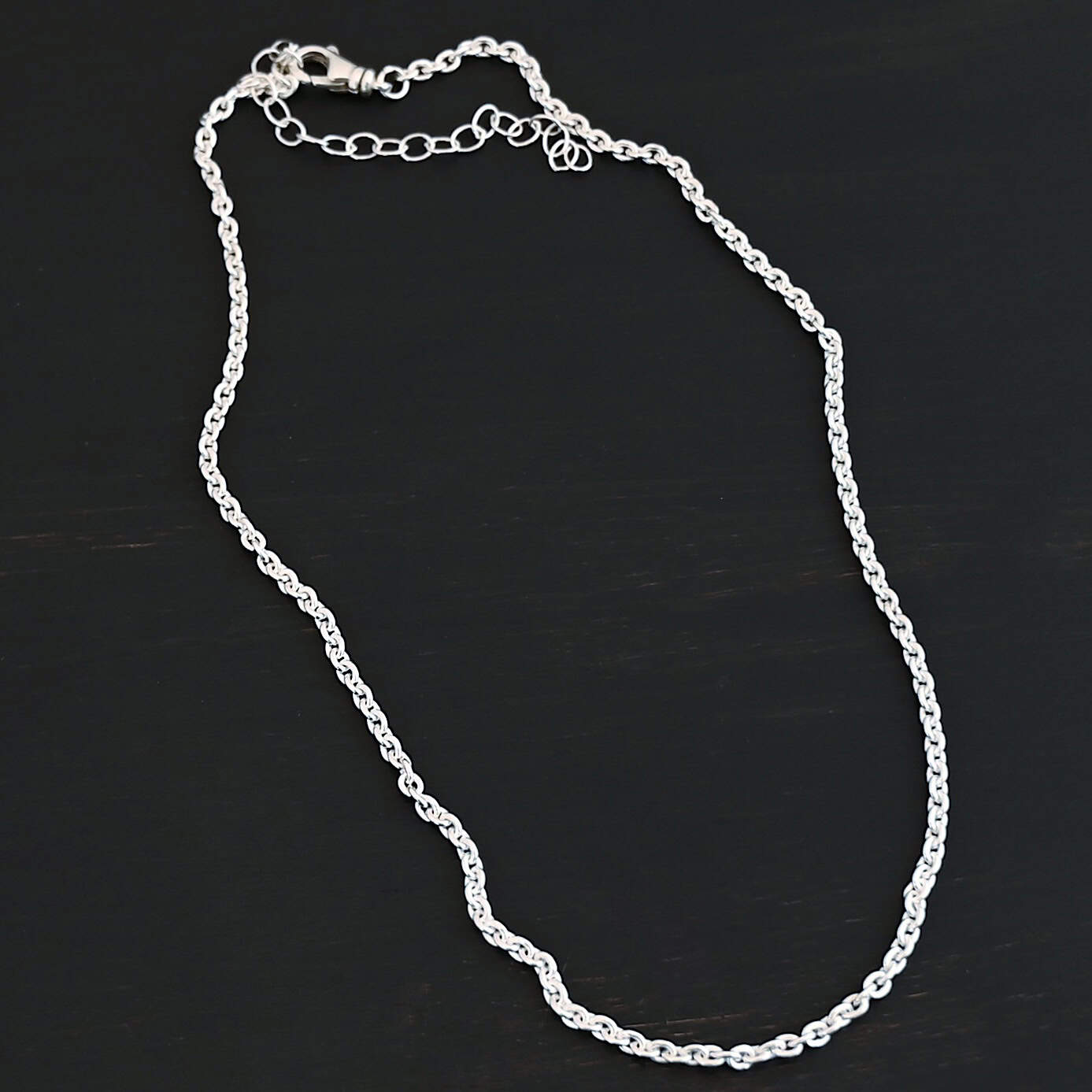 Savannah Chain Shiny Shiny sterling silver Savannah Chain with circle links that is resting against a dark background. Links measure 3x2mmx.7mm thick.