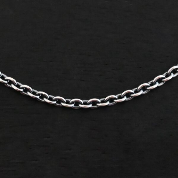 Close up of an oxidized sterling silver Savannah Chain with circle links that is laying against a dark background. Links measure 3x2mmx.7mm thick.