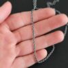 Oxidized sterling silver Savannah Chain with circle links that is laying on a hand that is resting against a dark background. Links measure 3x2mmx.7mm thick.
