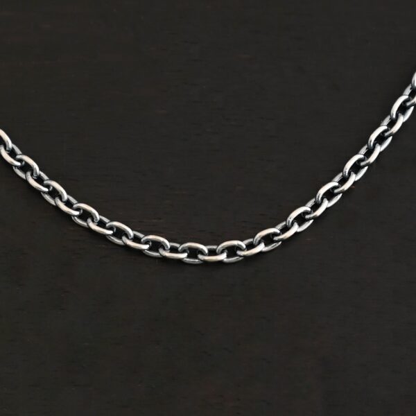 Close up of an oxidized sterling silver Maria Chain with circle links that is laying on a dark background. Links are 4x3mmx.8mm thick.