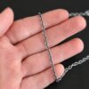 Oxidized sterling silver Maria chain with circle links that is laying on a hand which is resting against a dark background. Links are 4x3mmx.8mm thick.