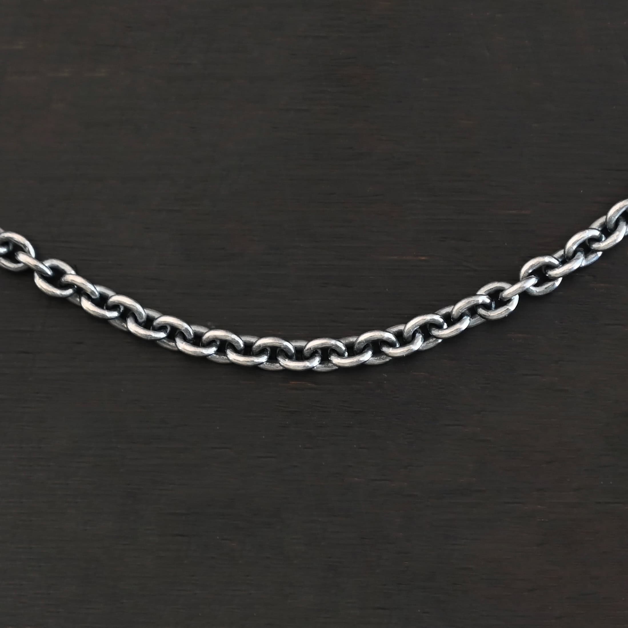 Close up of oxidized sterling silver Lauren chain with oval links laying against a dark background. Links measure 5x4mmx1mm thick.