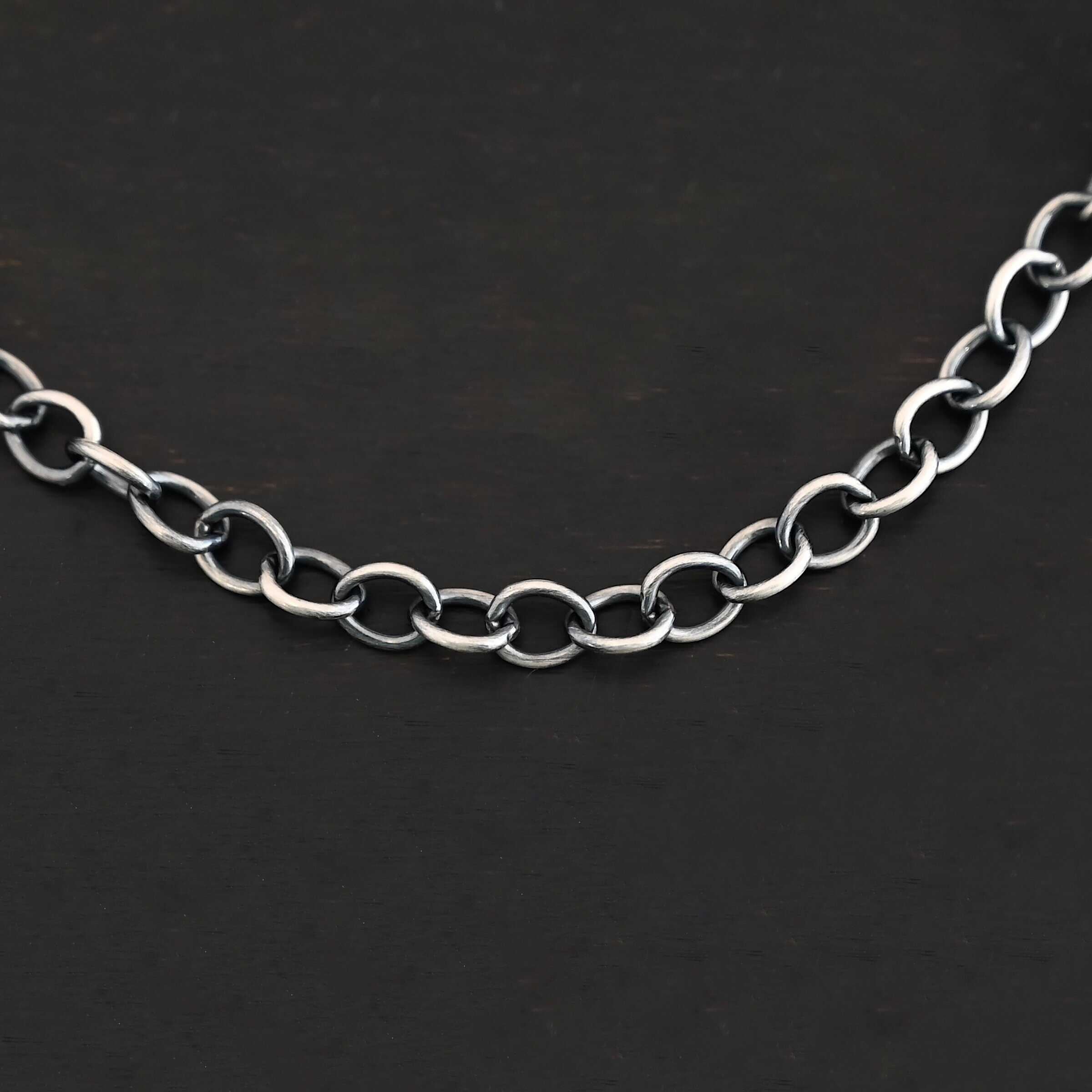 Jay Chain A close-up of the oxidized sterling silver Jay chain set against a dark black background. Links measure 7.2×5.7mm.