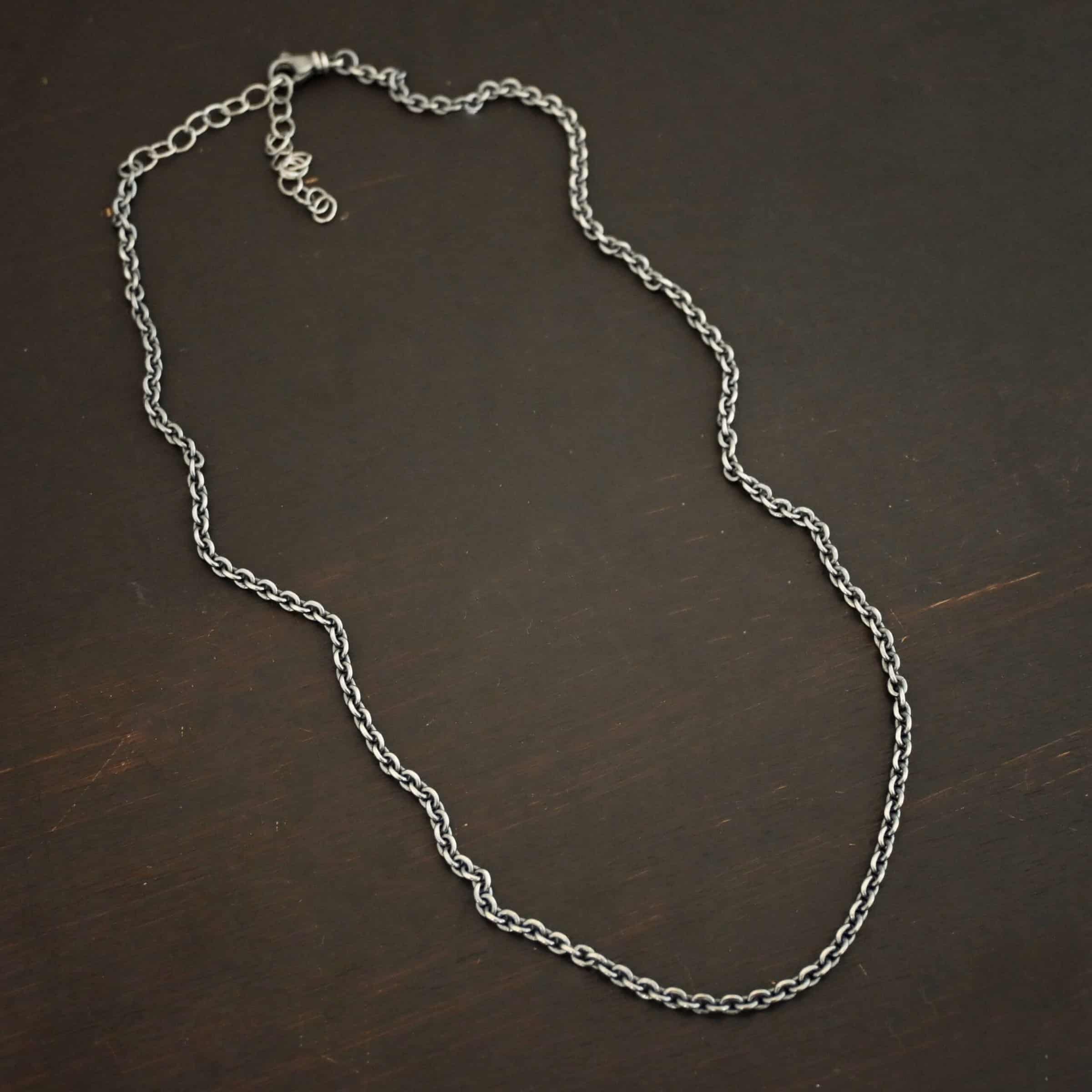 Maria Chain Oxidized sterling silver Maria chain with circle links that is laying on a dark background. Links are 4x3mmx.8mm thick.