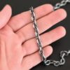Oxidized sterling silver Georgia Chain with thick oval links that measure 8x6mmx1.7mm thick lying on a hand that is resting against a dark background.