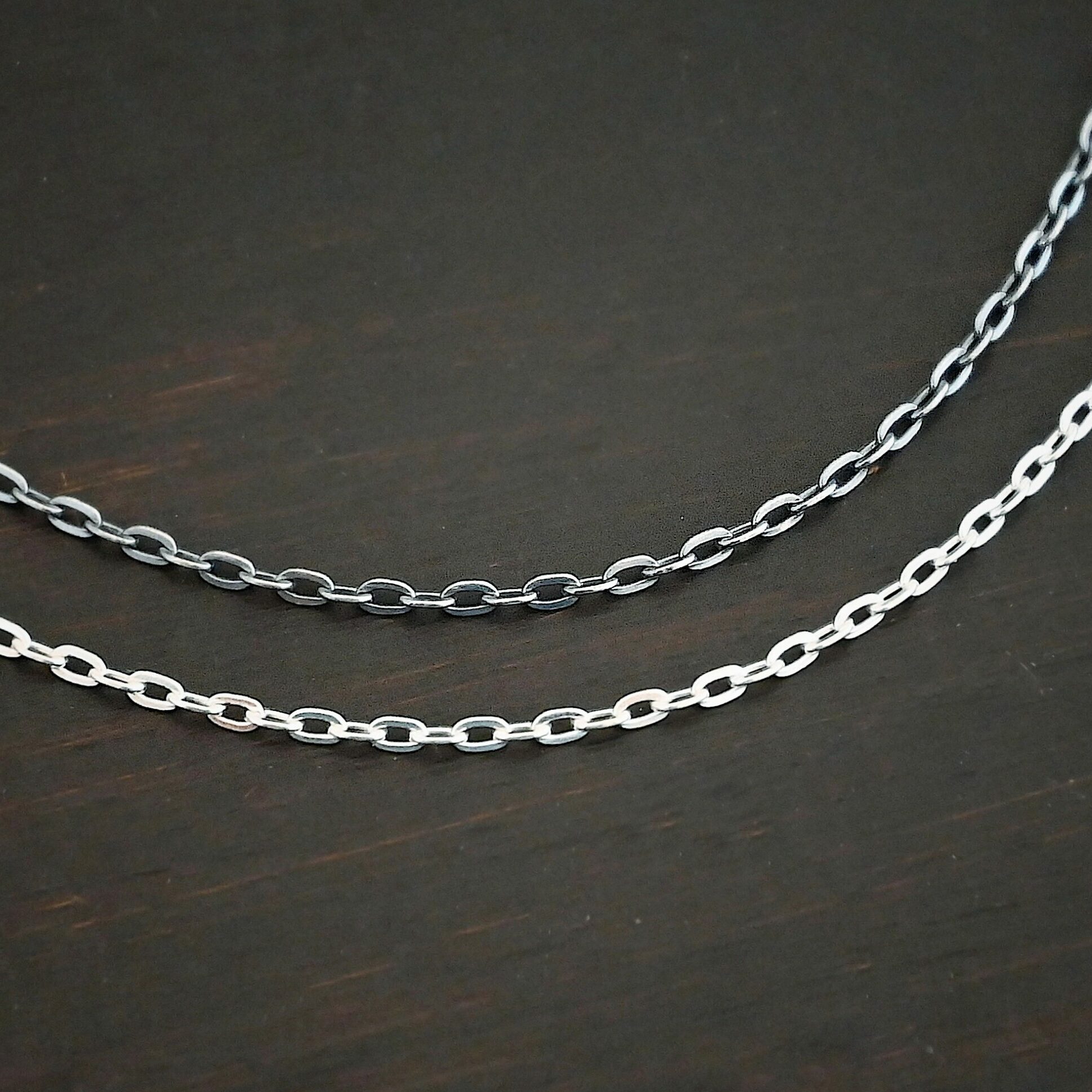 Cassandra Chain Close up of the "Cassandra" Chain as both shiny and oxidized. Oxidized chain is on top and the shiny is on the bottom. Chain has 2x2mm links. Chains are sitting against a dark background.