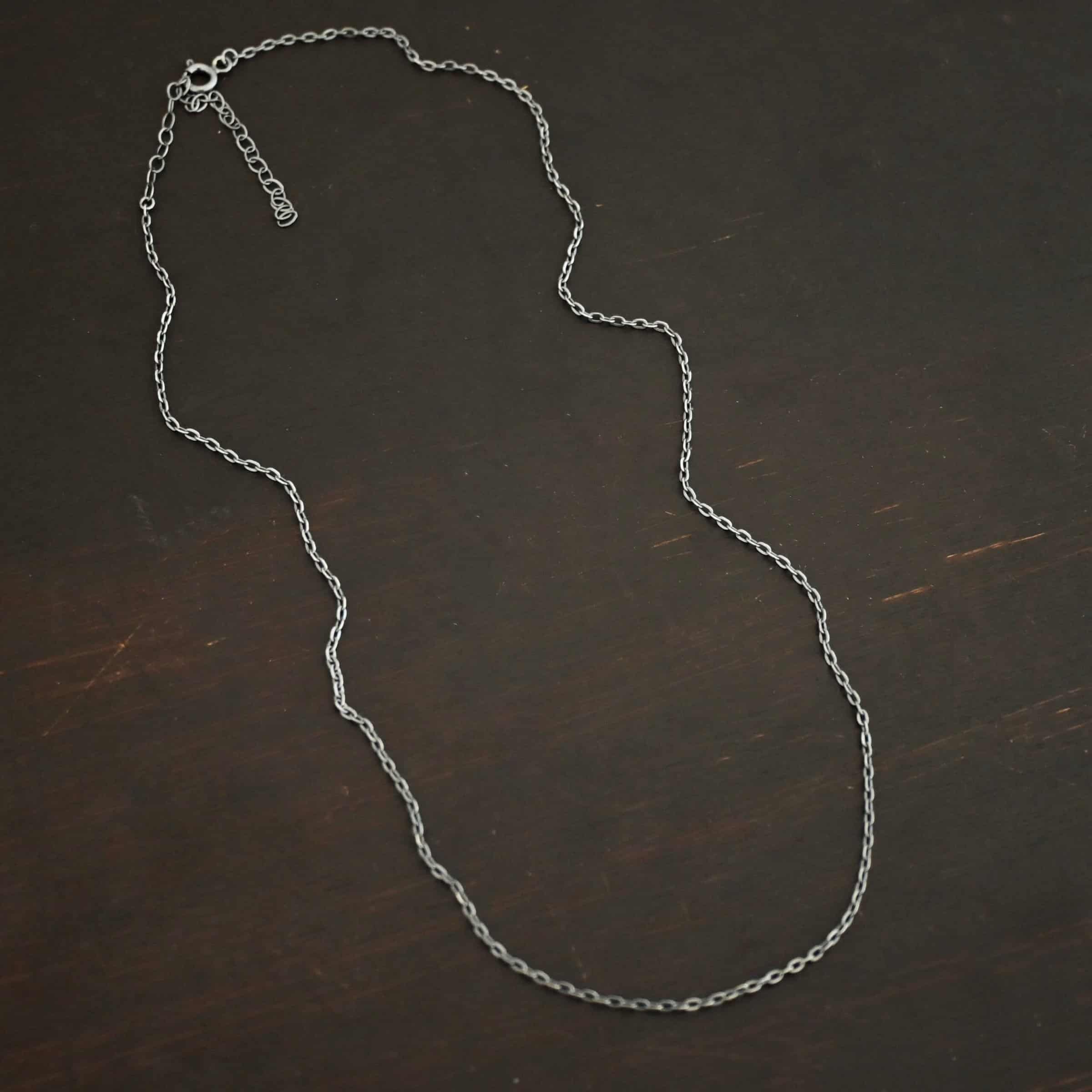 Cassandra Chain "Cassandra" Chain as shown lying against a dark background. Chain is shown as oxidized. Chain has 2x2mm links.