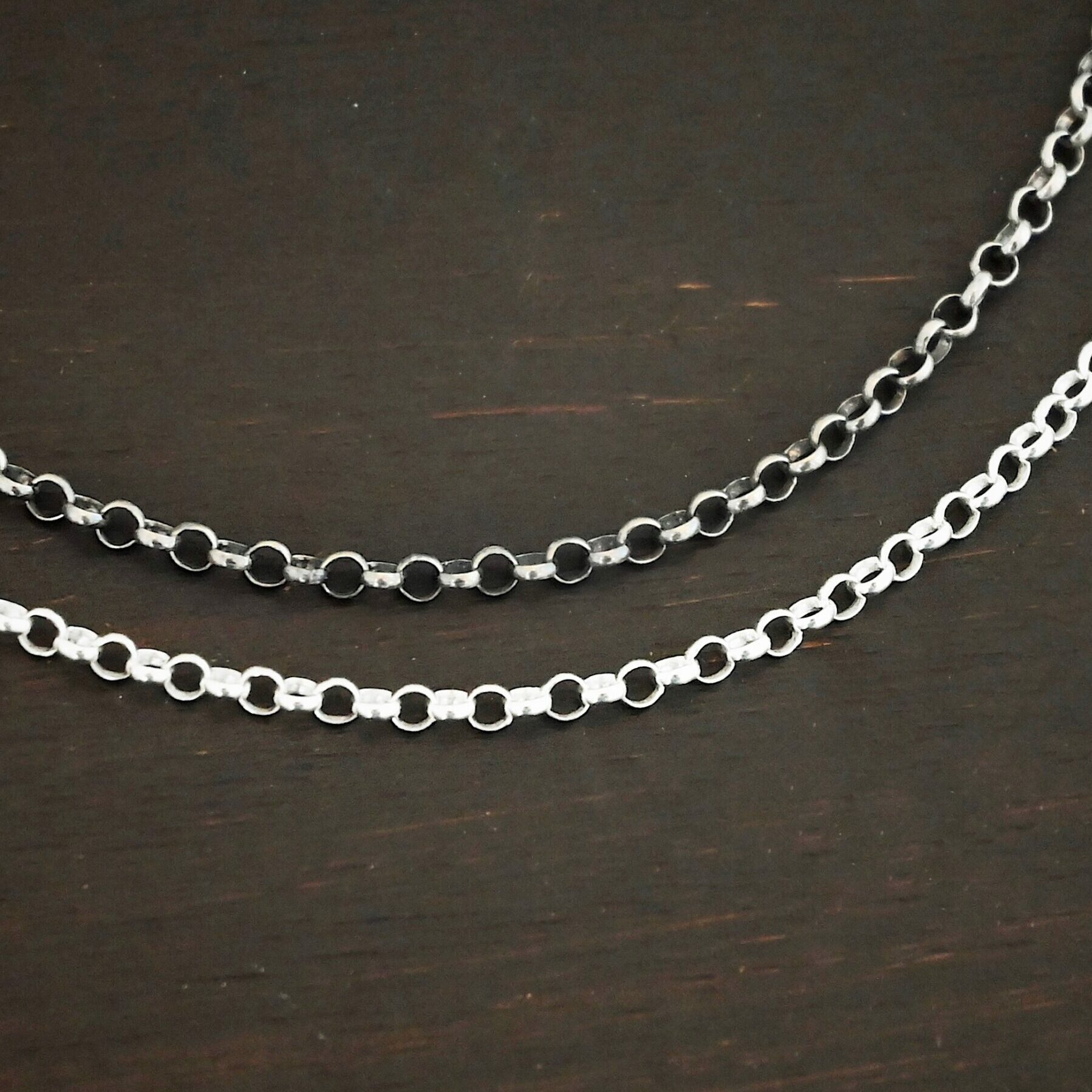 "Rachel Rolo" Chain as shiny and oxidized. Made out of sterling silver. Chain is made out of small, but thick circles that are connected to one another. The oxidized chain is on the top and shiny on the bottom.