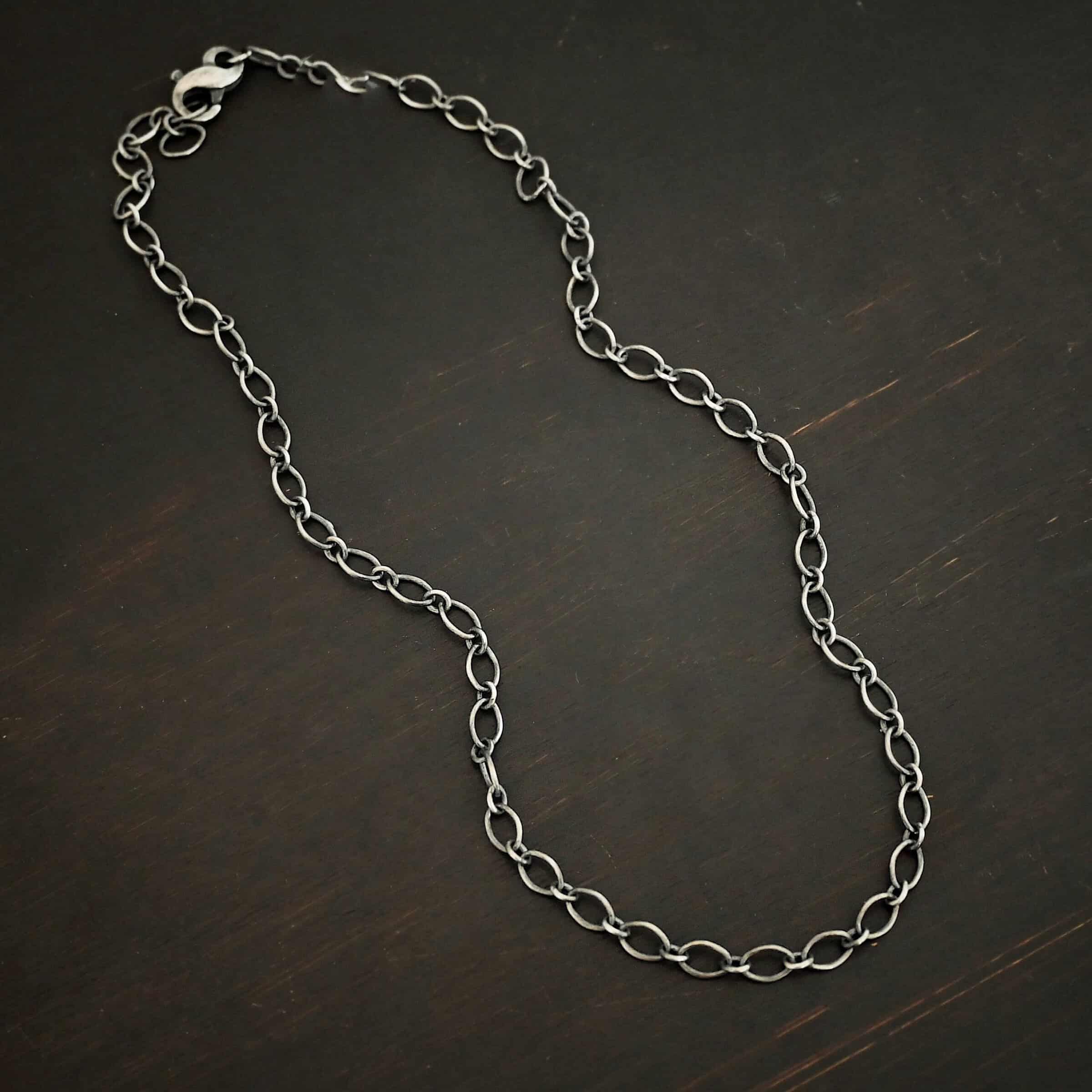 Allie Chain Sterling silver oxidized Allie oval chain shown on dark background. Oval links measure 7×4.6mm.