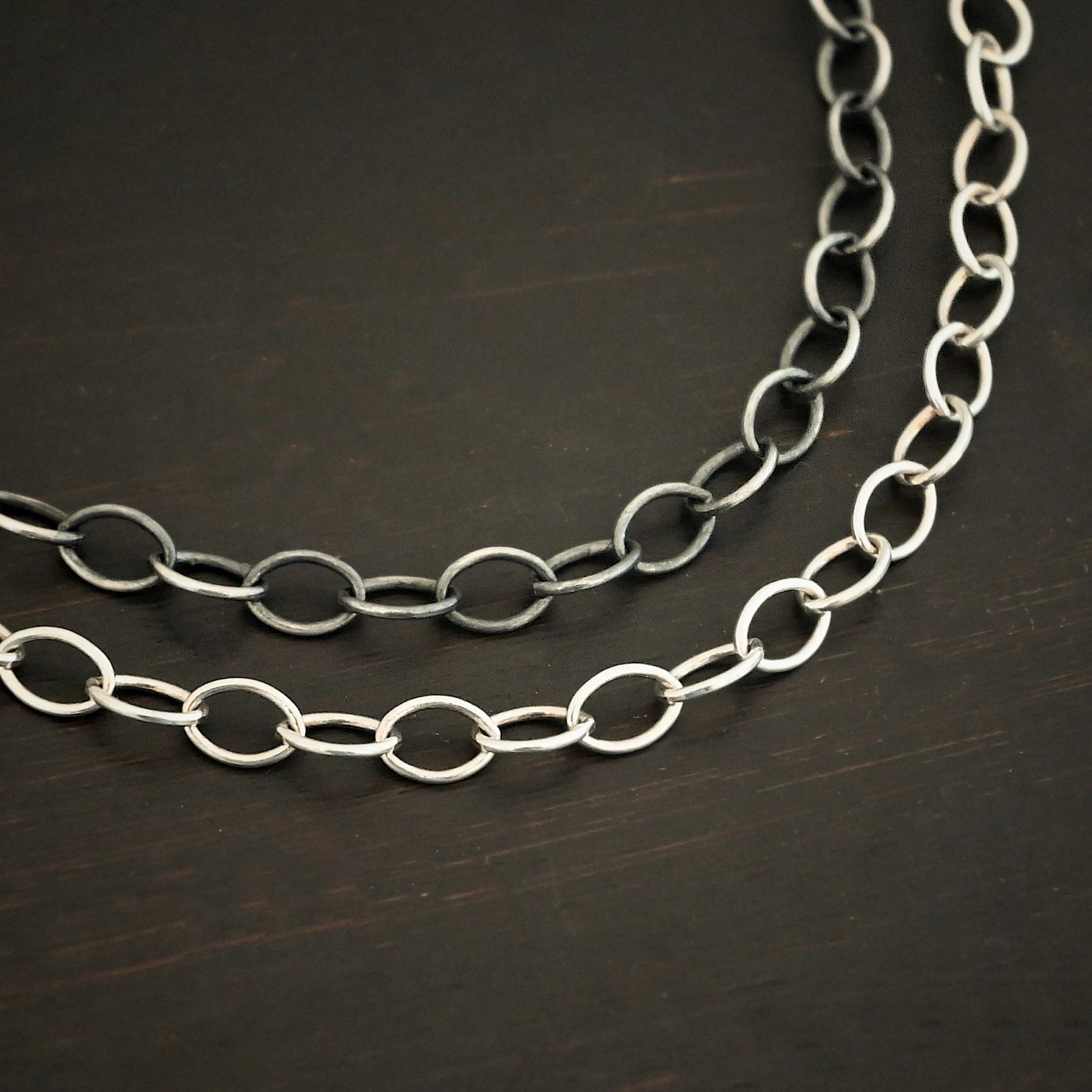 Willow Chain "Willow" Chain shown lying against a dark background. Oval links measure 6.5×4.7mm. Chain is shown as shiny and oxidized.