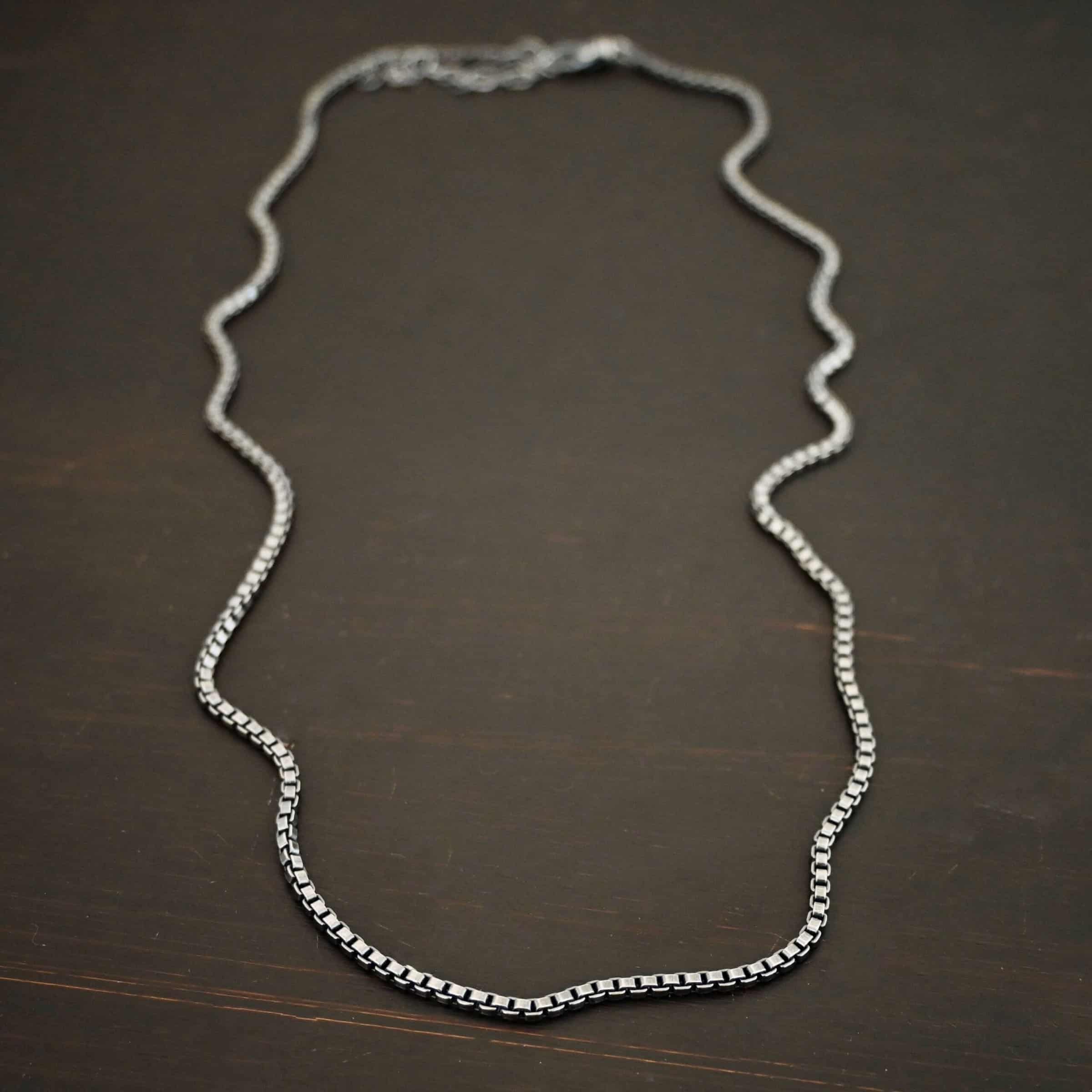 "Briggs Box" Chain as oxidized. Chain is made out of sterling silver and has box links that make up the chain. Chain is lying against the dark background. Heavy Box Chain 2.5mmx1.4mm.