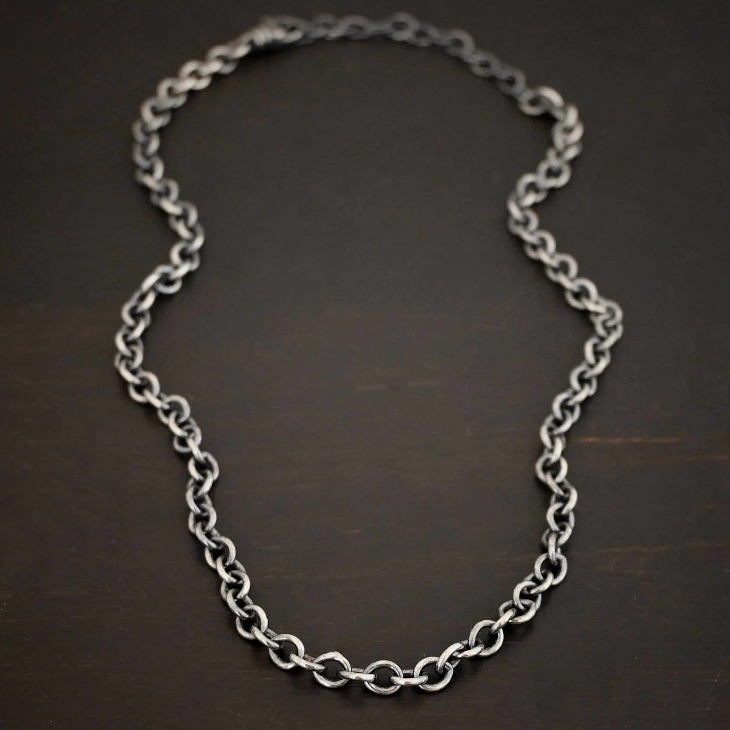 Oxidized sterling silver Joy chain with circular links laying on a dark background. Links measure 6.5×5.4mm.