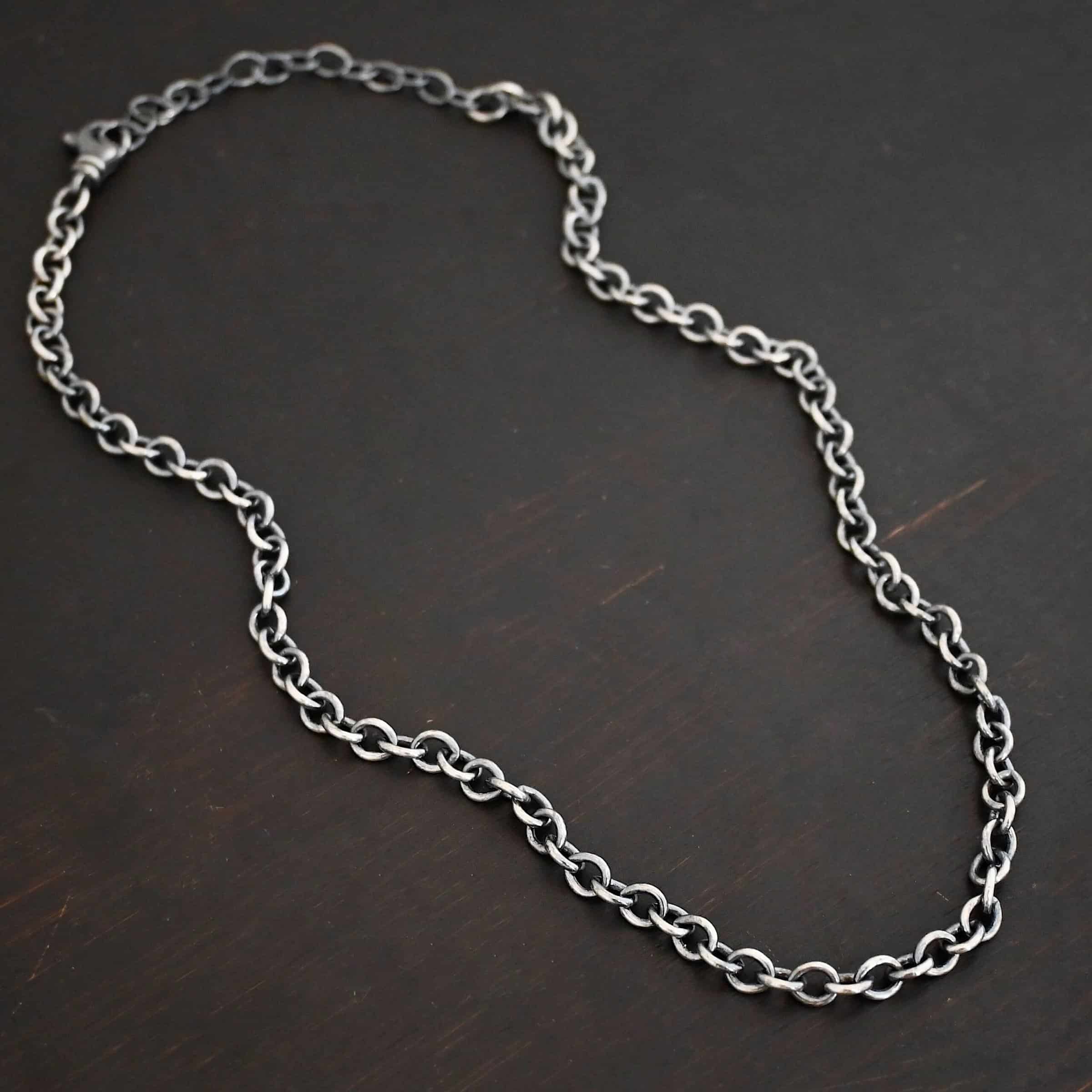 Oxidized sterling silver Joy chain with circular links laying on a dark background. Links measure 6.5×5.4mm.