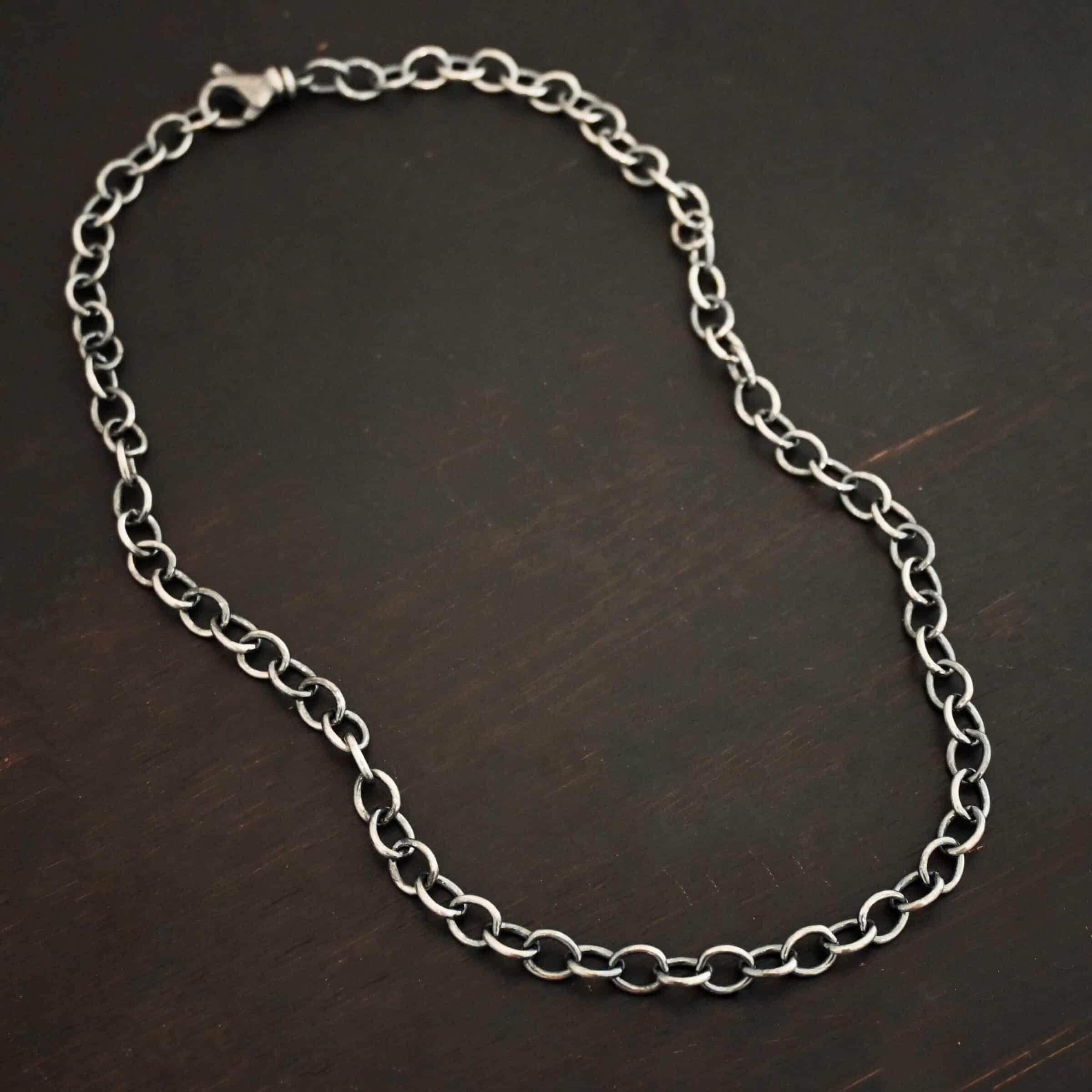 Jay Chain Oxidized Sterling silver Jay chain with circular links that measure 7.2×5.7mm set against a dark black background.