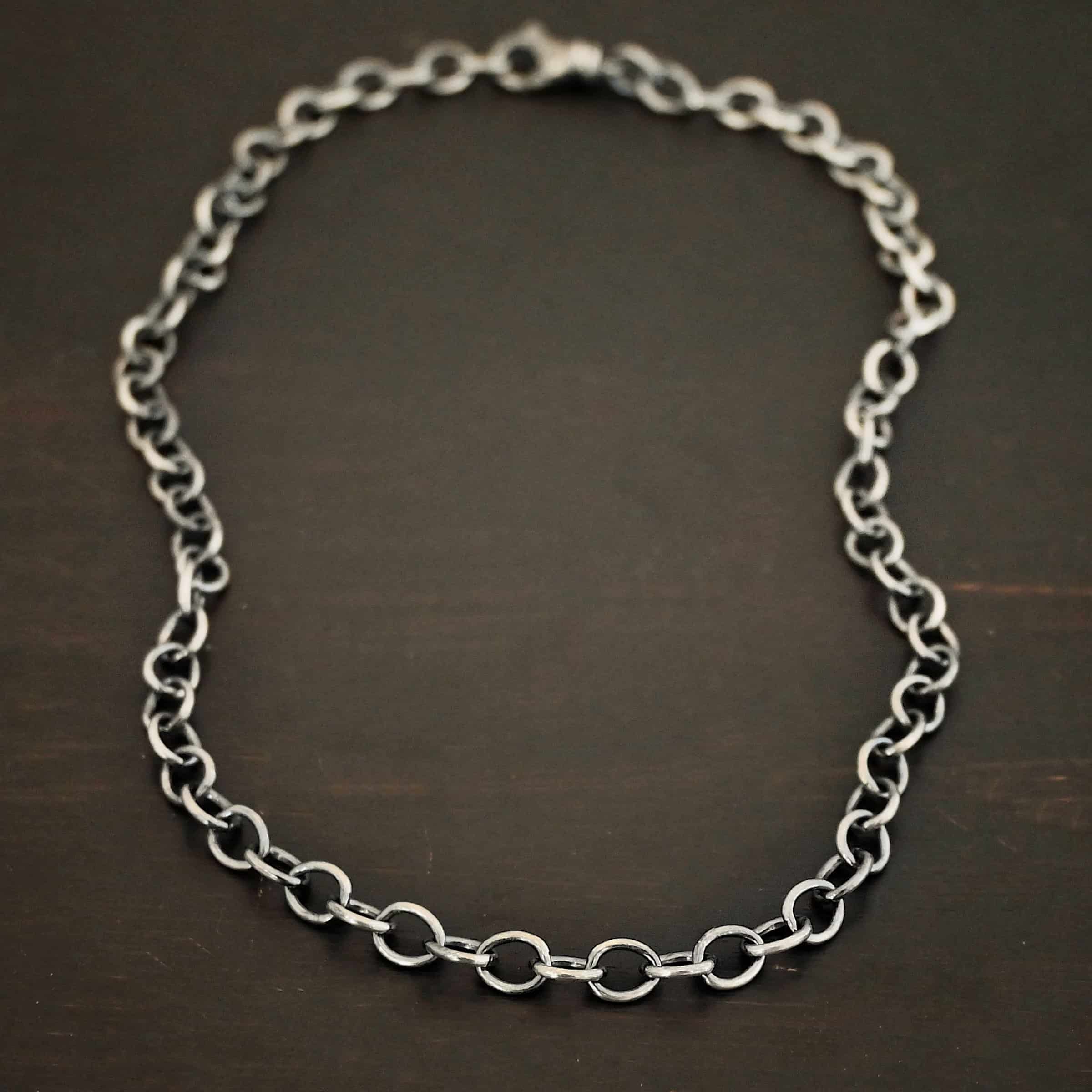 Jay Chain Oxidized Sterling silver Jay chain with circular links that measure 7.2×5.7mm set against a dark black background.
