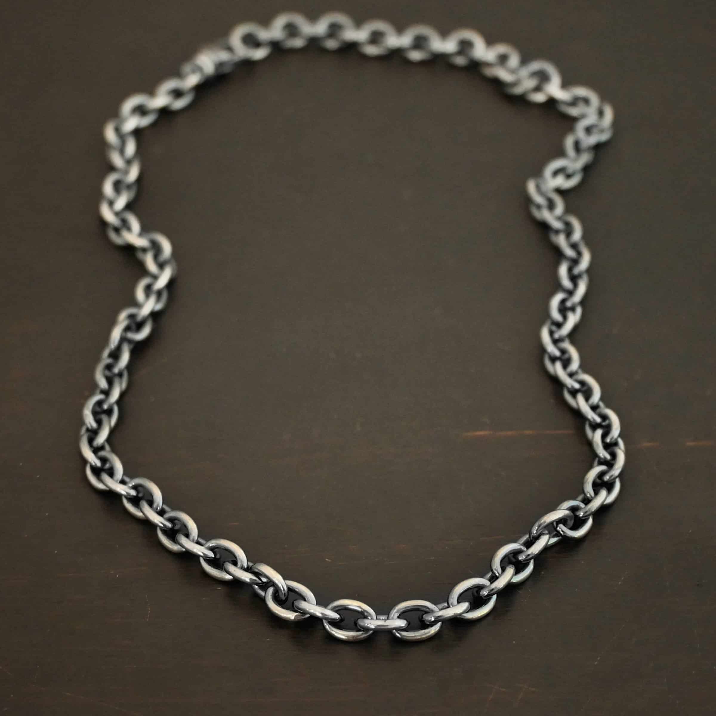 Oxidized sterling silver Georgia Chain with thick oval links that measure 8x6mmx1.7mm thick. Chain is resting against a dark background.