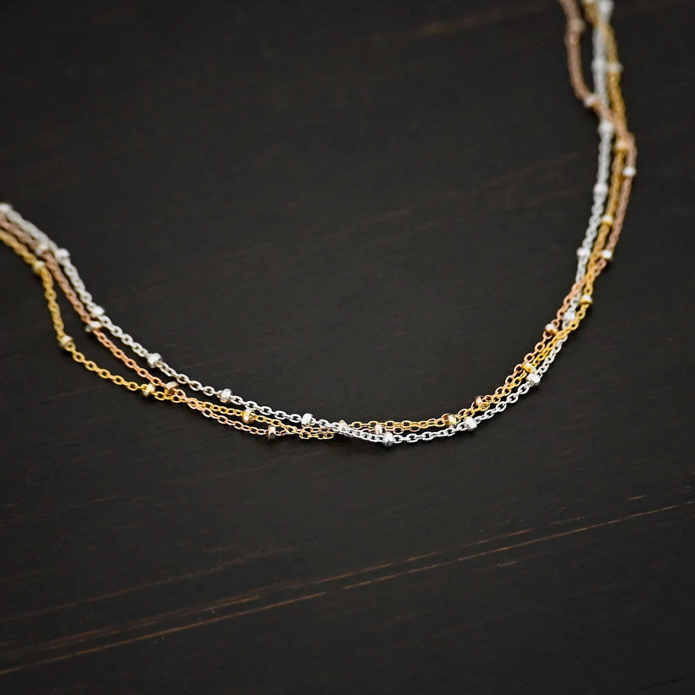 Champagne in Paris shiny "Champagne In Paris" Chain as shown up close. shiny Sterling Silver, 14K Rose Gold Filled, & 14K Yellow Gold Filled chain 1.2mm thick. Chain is shown against a dark background.