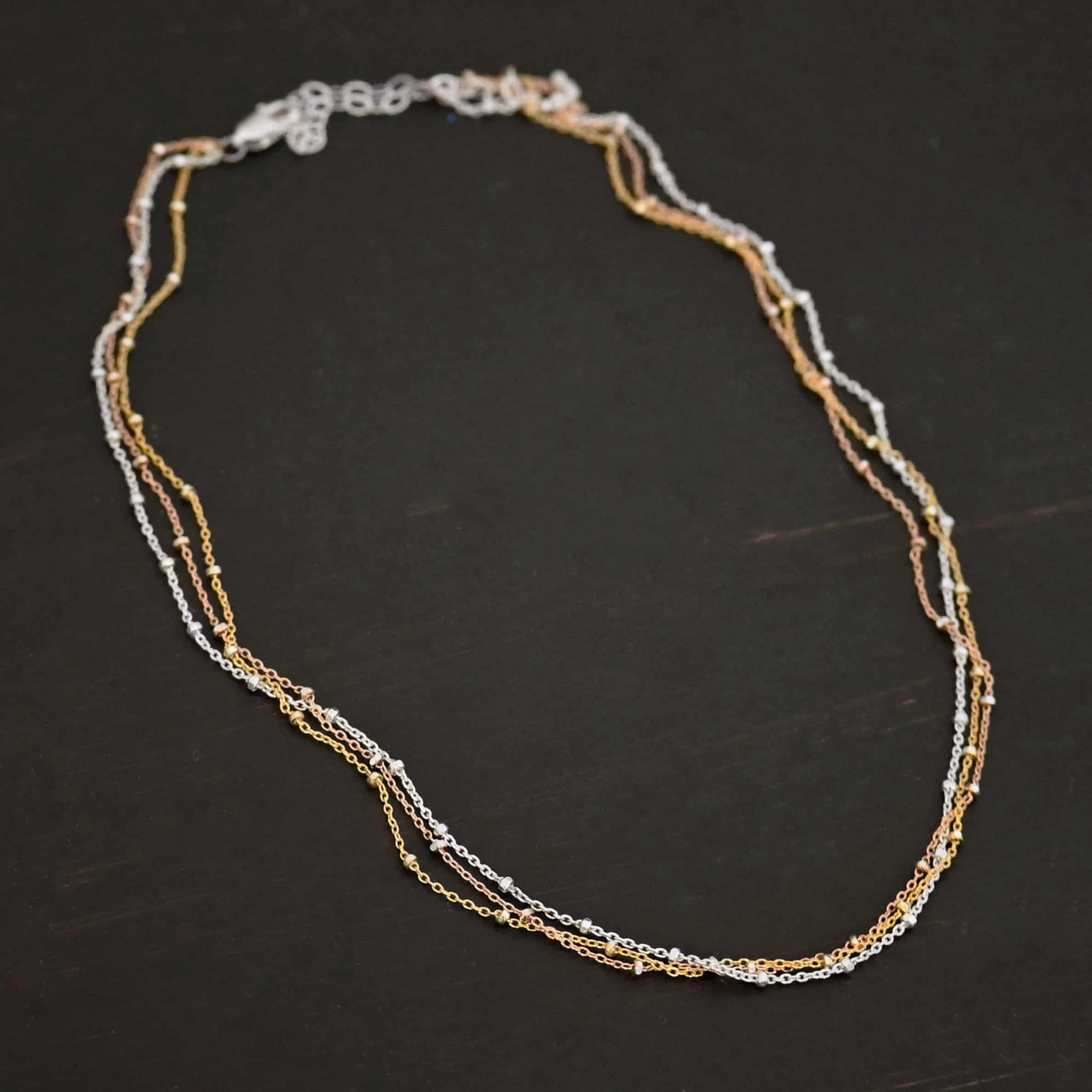 Champagne in Paris shiny "Champagne In Paris" Chain as shown up close. shiny Sterling Silver, 14K Rose Gold Filled, & 14K Yellow Gold Filled chain 1.2mm thick. Chain is shown against a dark background.