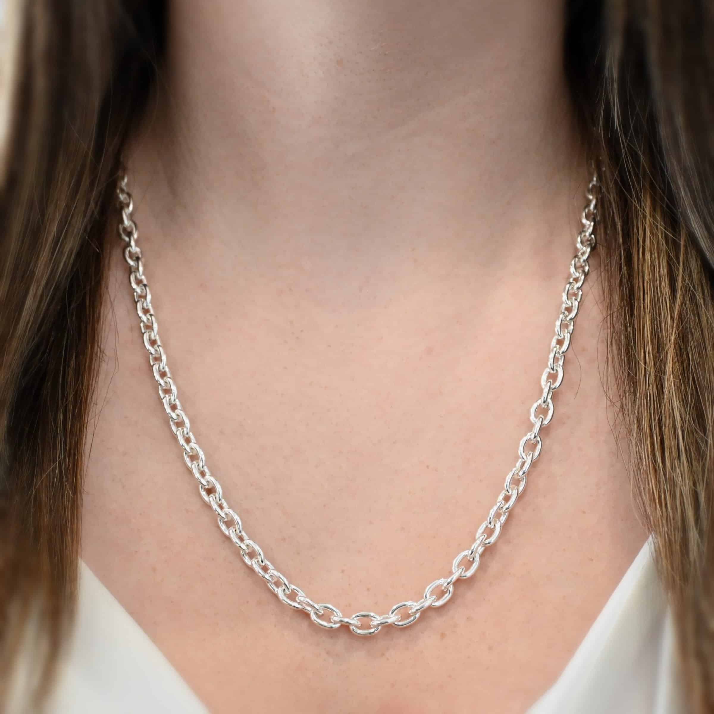 Close up of the "Georgia" Chain as shown on a model. Heavy links measure 8x6mmx1.7mm thick. Chain is shown at 22" long and shiny. Model is wearing a white v-neck shirt.