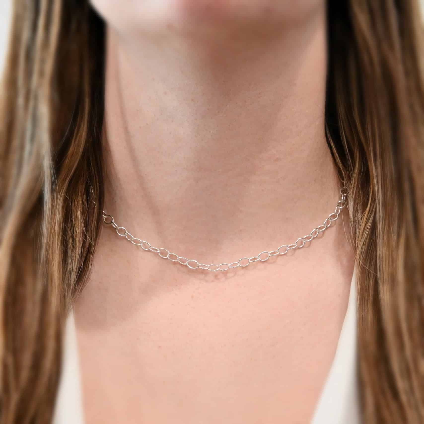 Willow Chain, 16", Shiny "Willow" Chain is shown on a model. Chain is shown as shiny and 16" long. Oval links measure 6.5×4.7mm. Model is wearing a white v-neck shirt.