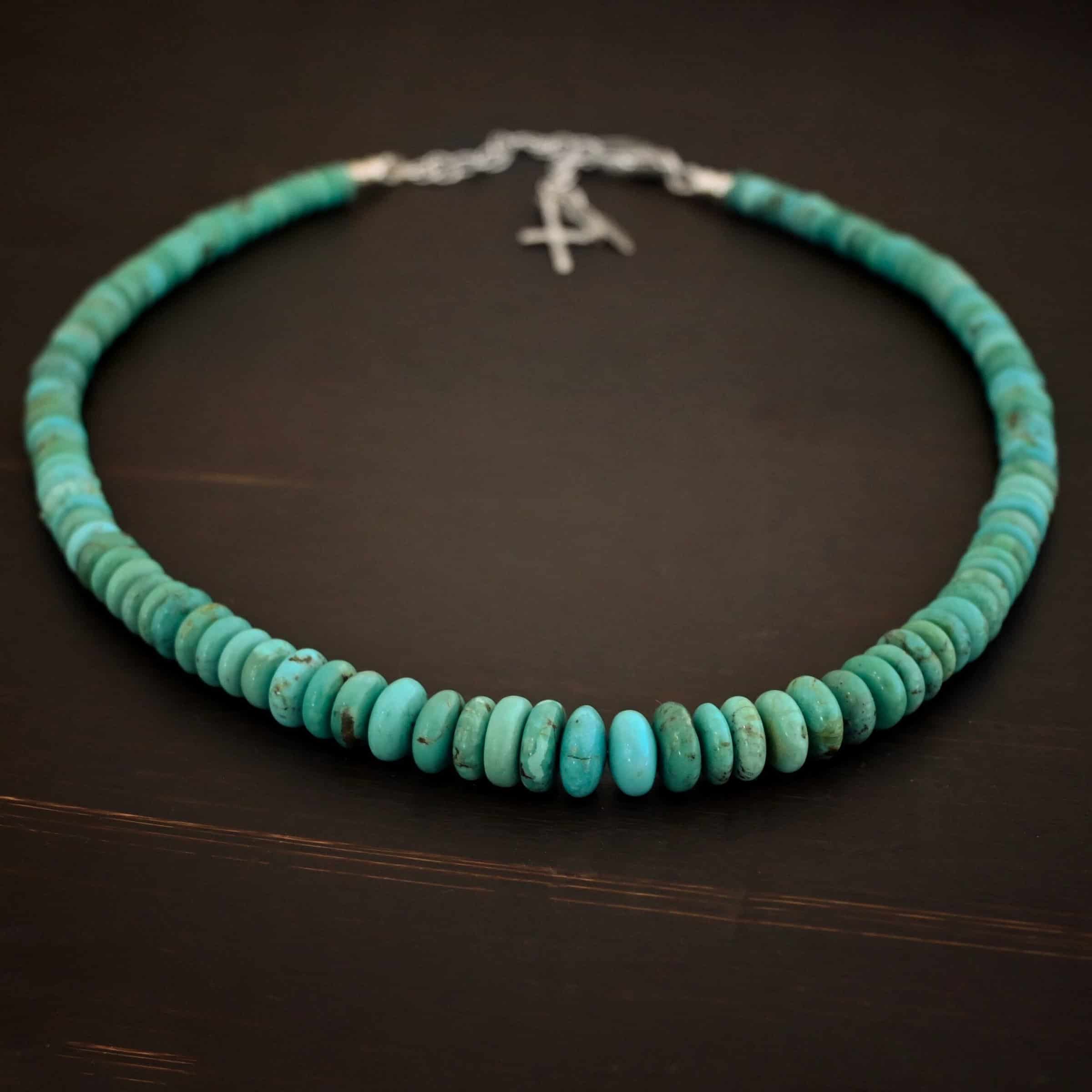 Bonnie Small Photo of the "Bonnie" Necklace. Made out of sterling silver and turquoise. Beads are varying shades of blueish green colors. The beads graduate in size slightly as they get towards the center. Beads are strung tightly together. Necklace is lying against a dark background.