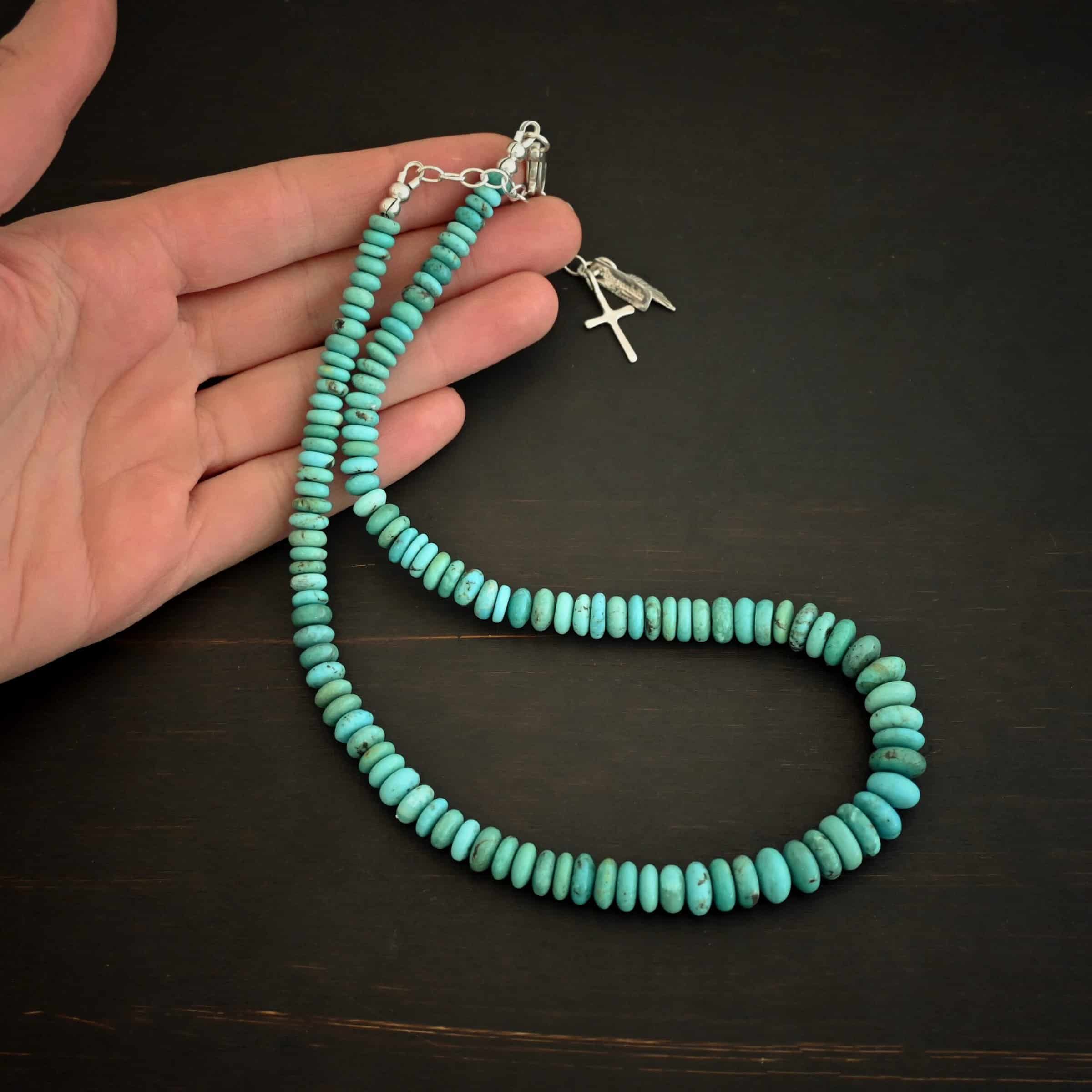 Bonnie Small Photo of the "Bonnie" Necklace. Made out of sterling silver and turquoise. Beads are varying shades of blueish green colors. The beads graduate in size slightly as they get towards the center. Beads are strung tightly together. Necklace is lying against the fingertips of a hand to demonstrate size.