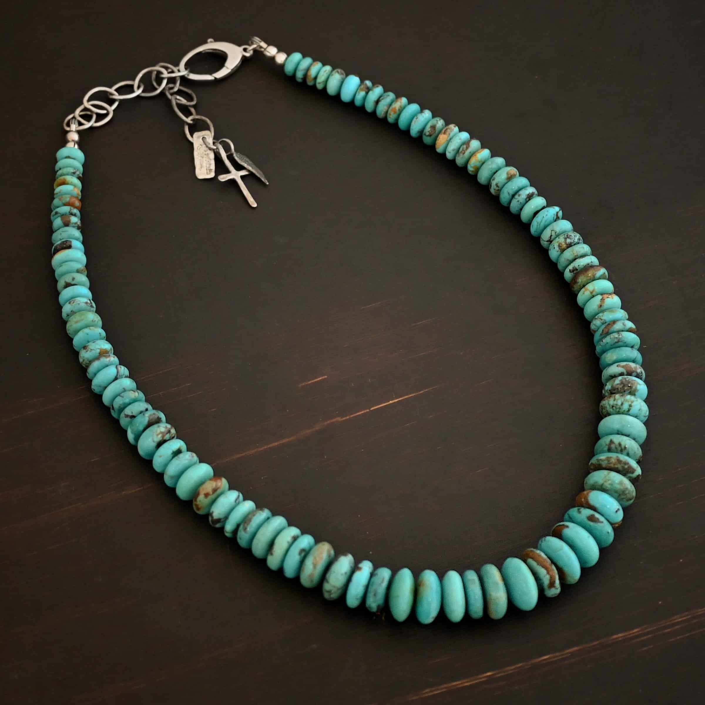 Bonnie Large Photo of the "Bonnie" Necklace. Made out of sterling silver and turquoise. Beads are varying shades of blueish green colors. The beads graduate in size as they get towards the center. Beads are strung tightly together. Necklace is lying against a dark background.