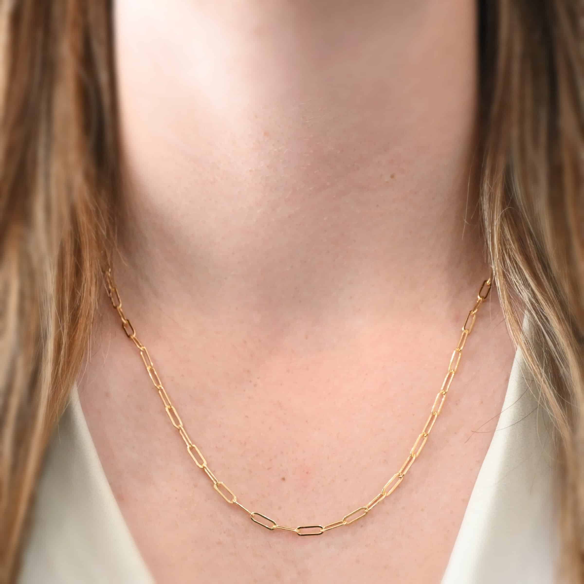 Lulu Link Chain "Lulu Link" Chain as shown on a model. Model is wearing a 20 inch 14k gold filled Lulu Link Chain. Links are 8.5x3x2mm. Model is wearing a white v-neck shirt.