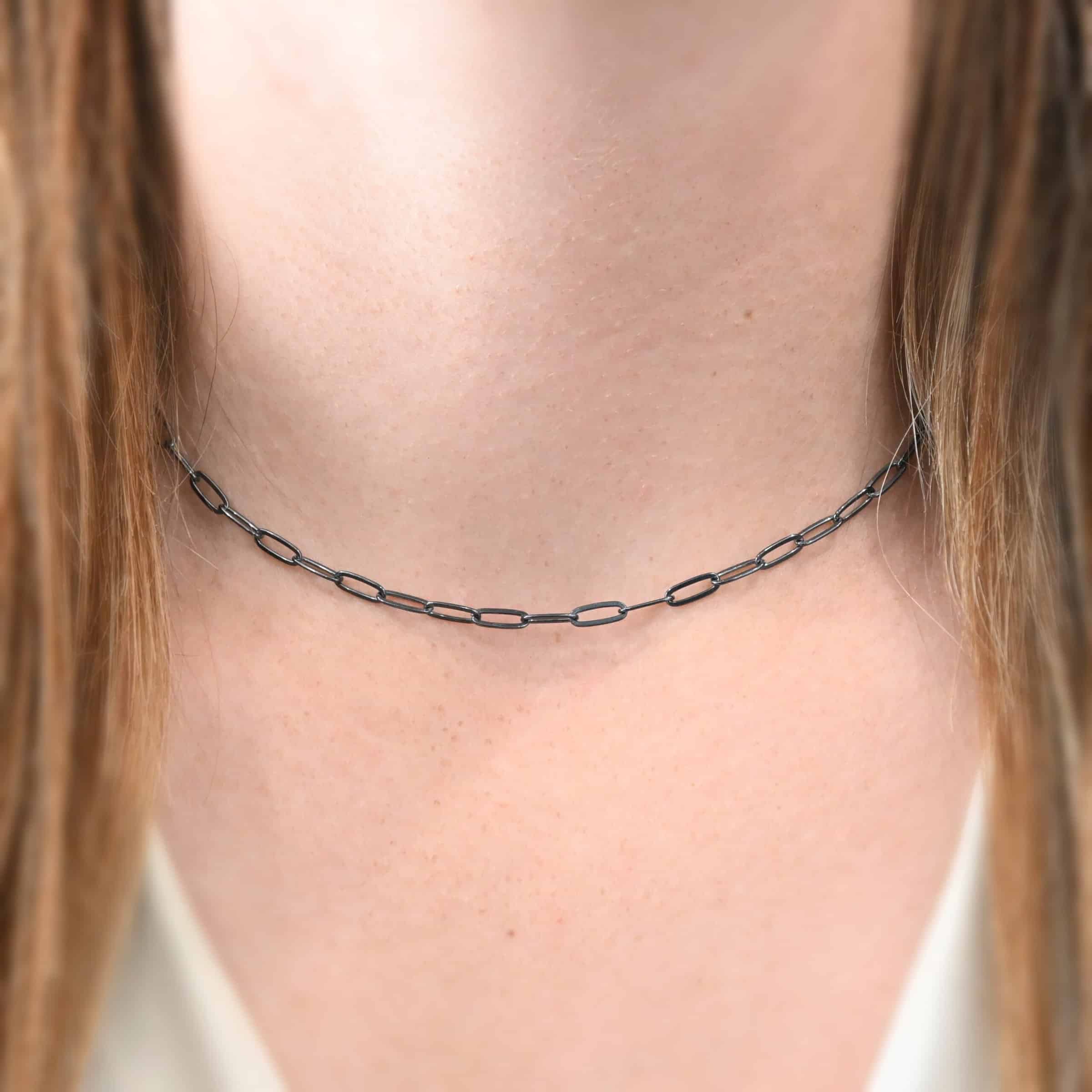 Lulu Link Chain "Lulu Link" Chain as shown on a model. Model is wearing a 16 inch oxidized Lulu Link Chain. Links are 8.5x3x2mm. Model is wearing a white v-neck shirt.