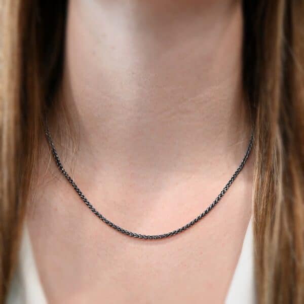 "Frenchie" Chain as shown up close and on a model. Chain is shown at 18 inches and with an oxidized finish. Model is wearing a white v-neck shirt.