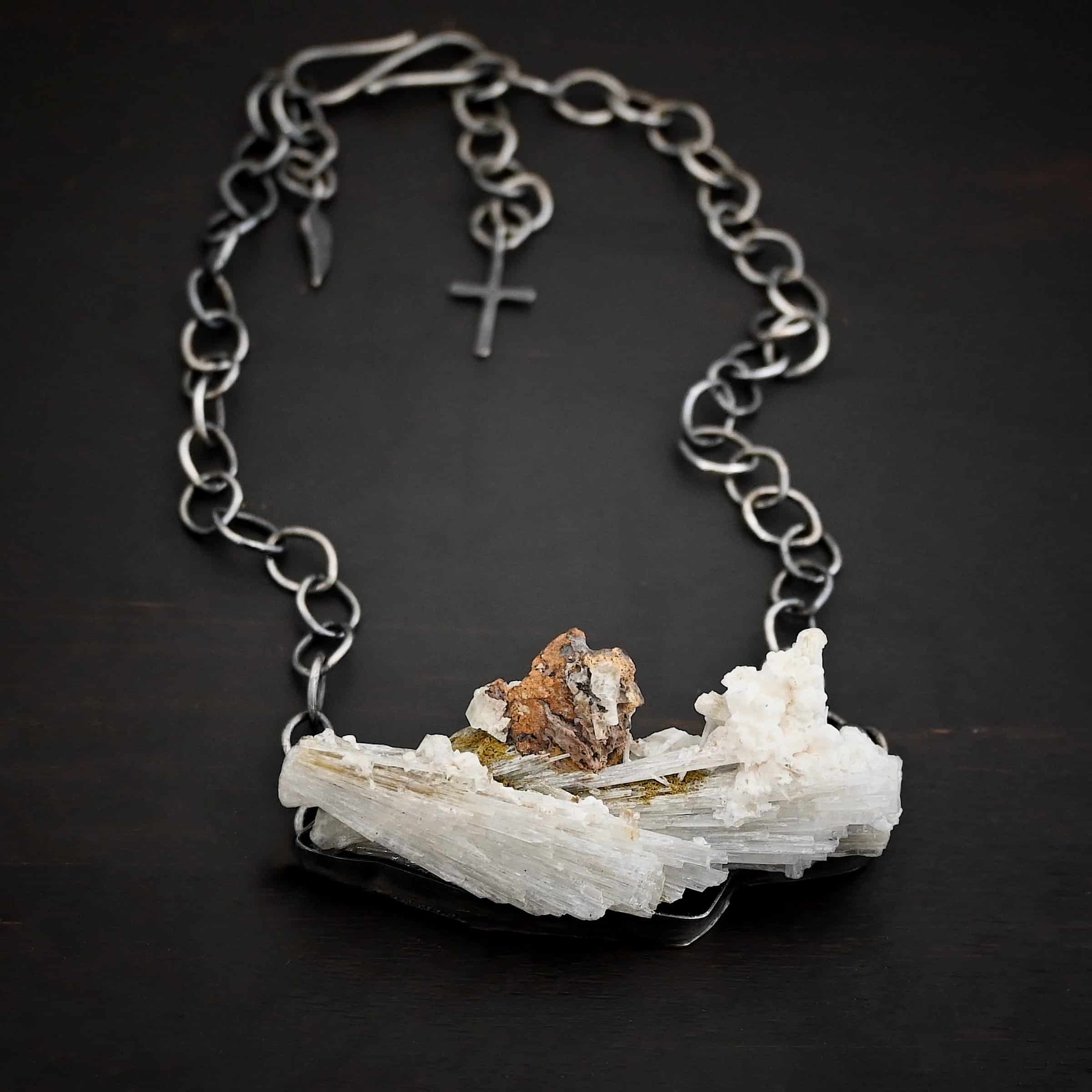 Driftwood Necklace Photo of the "Driftwood" Necklace. Necklace is made out of sterling silver and calcitite. Pendant measures 1x3." The calcitite is jagged, and rough cut. Comes on a sterling silver "Sky" chain that is oxidized with large circle links. Necklace is lying against a dark background.