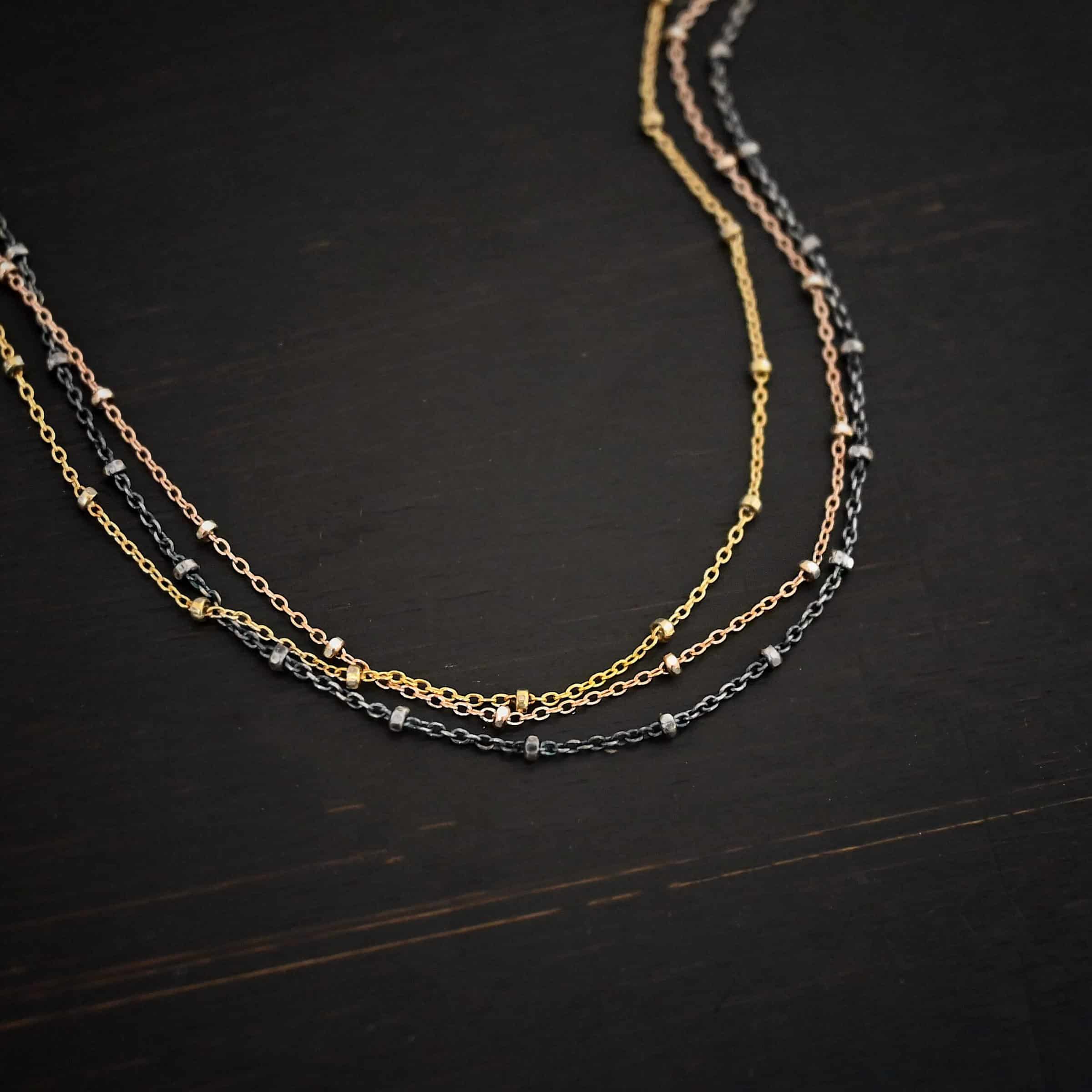 Champagne in Paris ox "Champagne In Paris" Chain as shown up close. oxidized Sterling Silver, 14K Rose Gold Filled, & 14K Yellow Gold Filled chain 1.2mm thick. Chain is shown against a dark background.