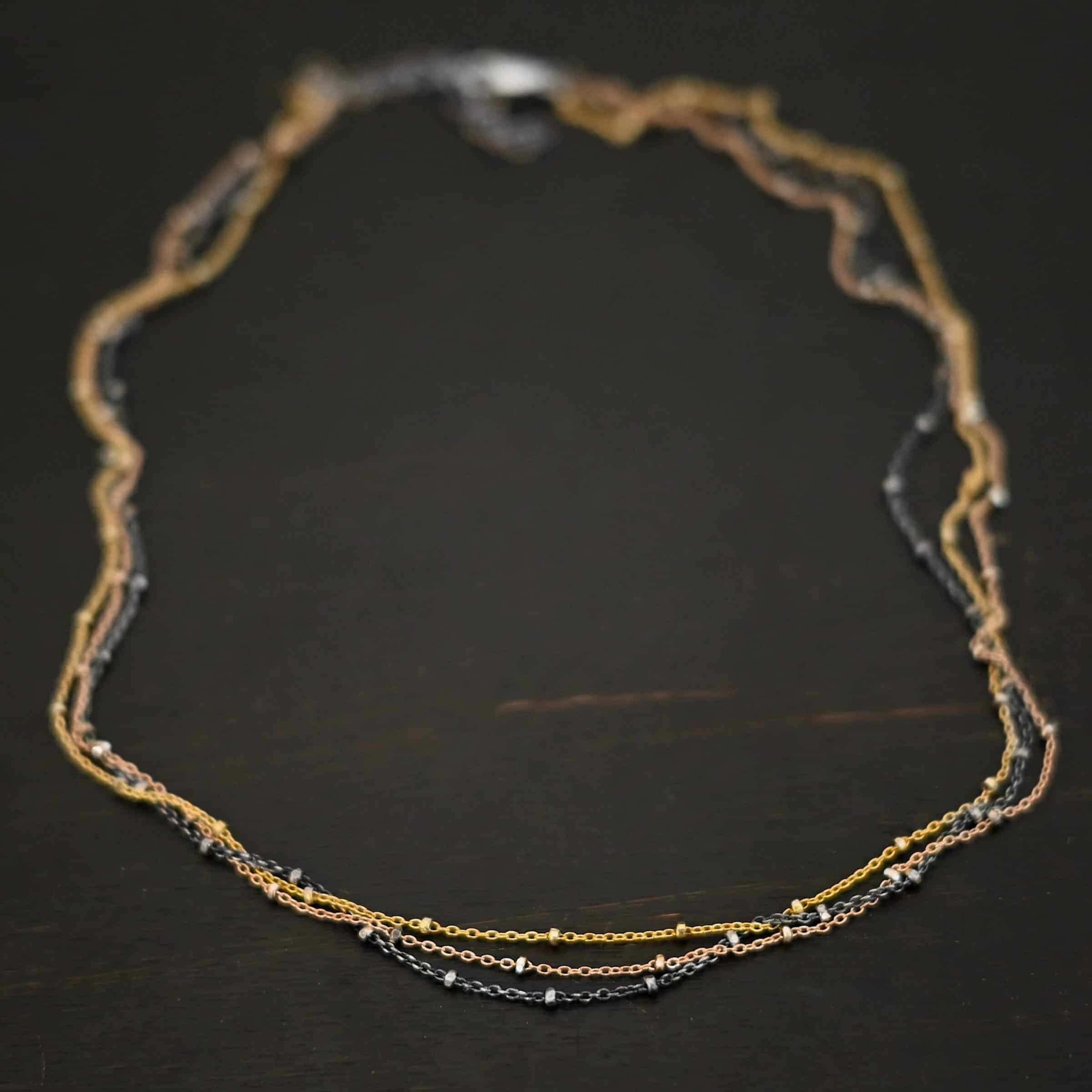 Champagne in Paris ox "Champagne In Paris" Chain as shown up close. oxidized Sterling Silver, 14K Rose Gold Filled, & 14K Yellow Gold Filled chain 1.2mm thick. Chain is shown against a dark background.