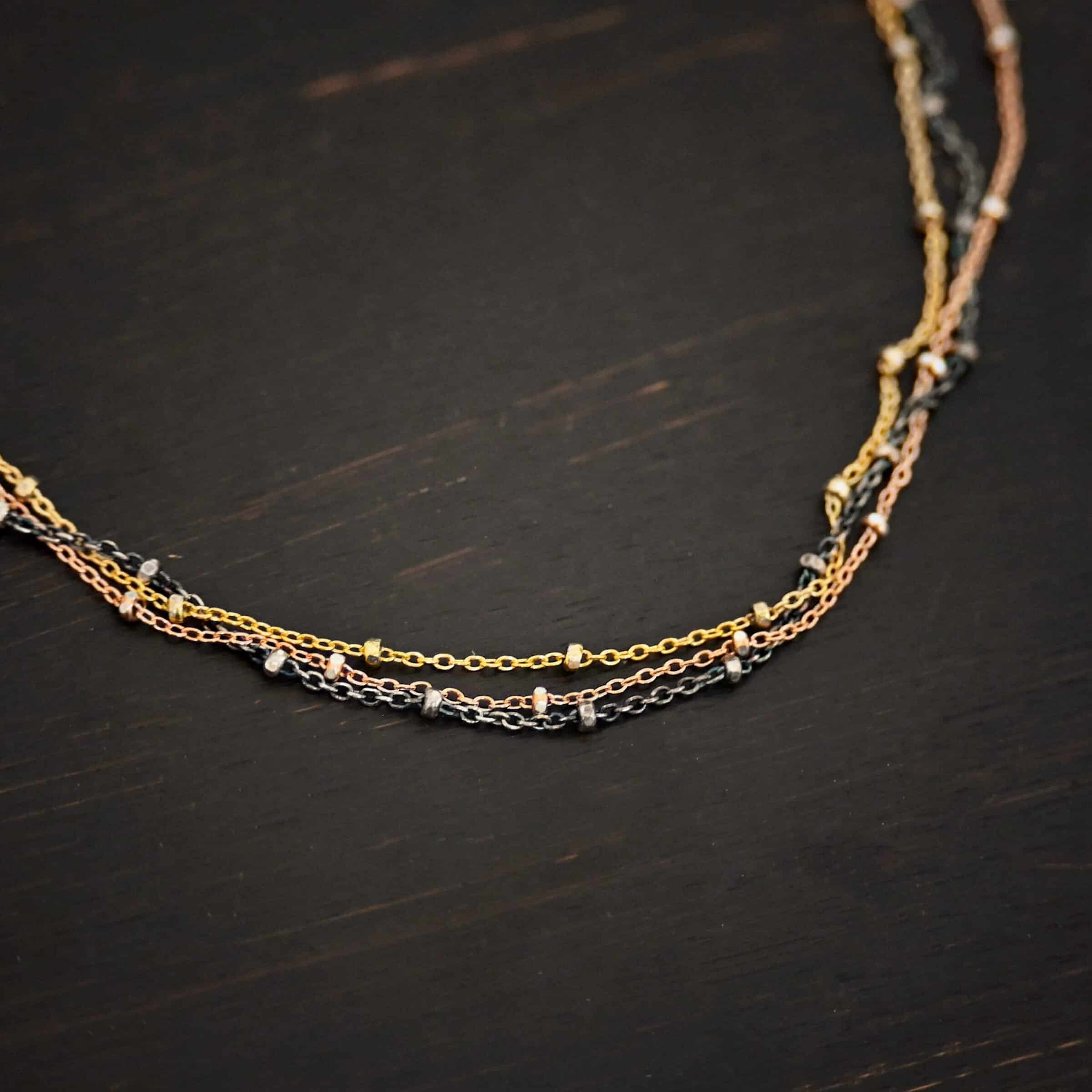 Champagne in Paris ox "Champagne In Paris" Chain as shown up close. oxidized Sterling Silver, 14K Rose Gold Filled, & 14K Yellow Gold Filled chain 1.2mm thick. Chain is shown against a dark background.