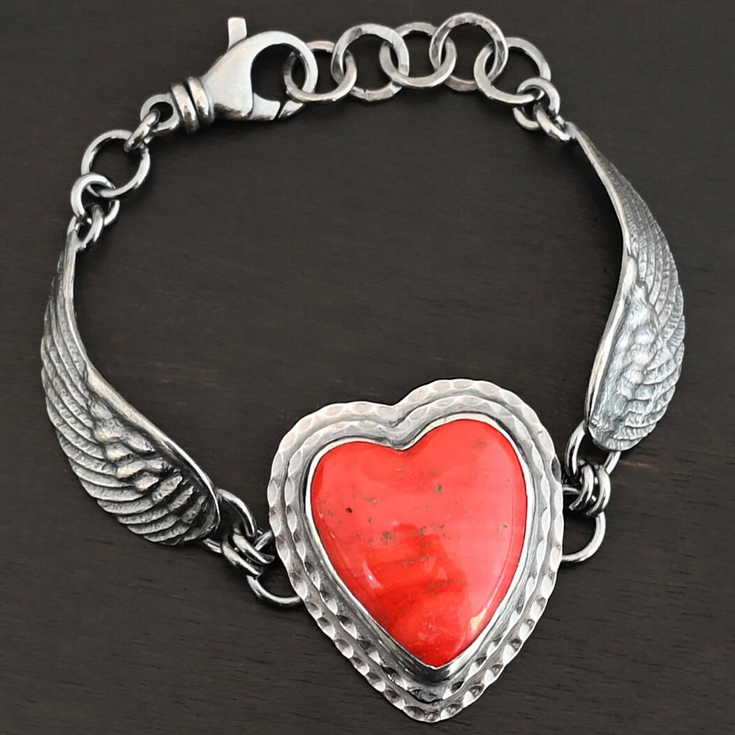 Heart On Fire Bracelet "Heart On Fire" Bracelet. The bracelet is a rosarita heart with medium sized angel wings on each side. The angel wings curve lightly so they can fit around the wrist. There is two layers of hammered sterling silver around the heart. Bracelet has a silver lobster claw clasp.