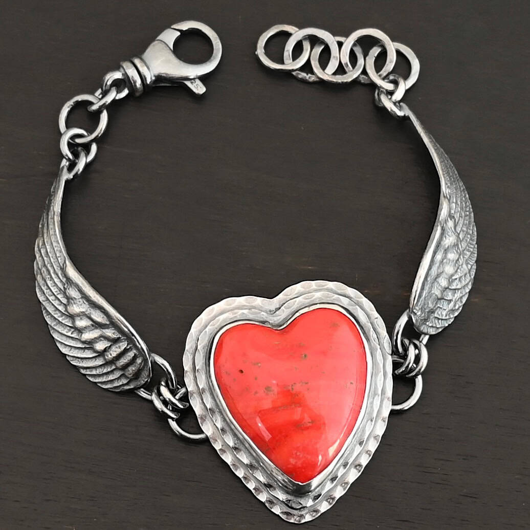 Heart On Fire Bracelet "Heart On Fire" Bracelet. The bracelet is a rosarita heart with medium sized angel wings on each side. The angel wings curve lightly so they can fit around the wrist. There is two layers of hammered sterling silver around the heart. Bracelet has a silver lobster claw clasp.