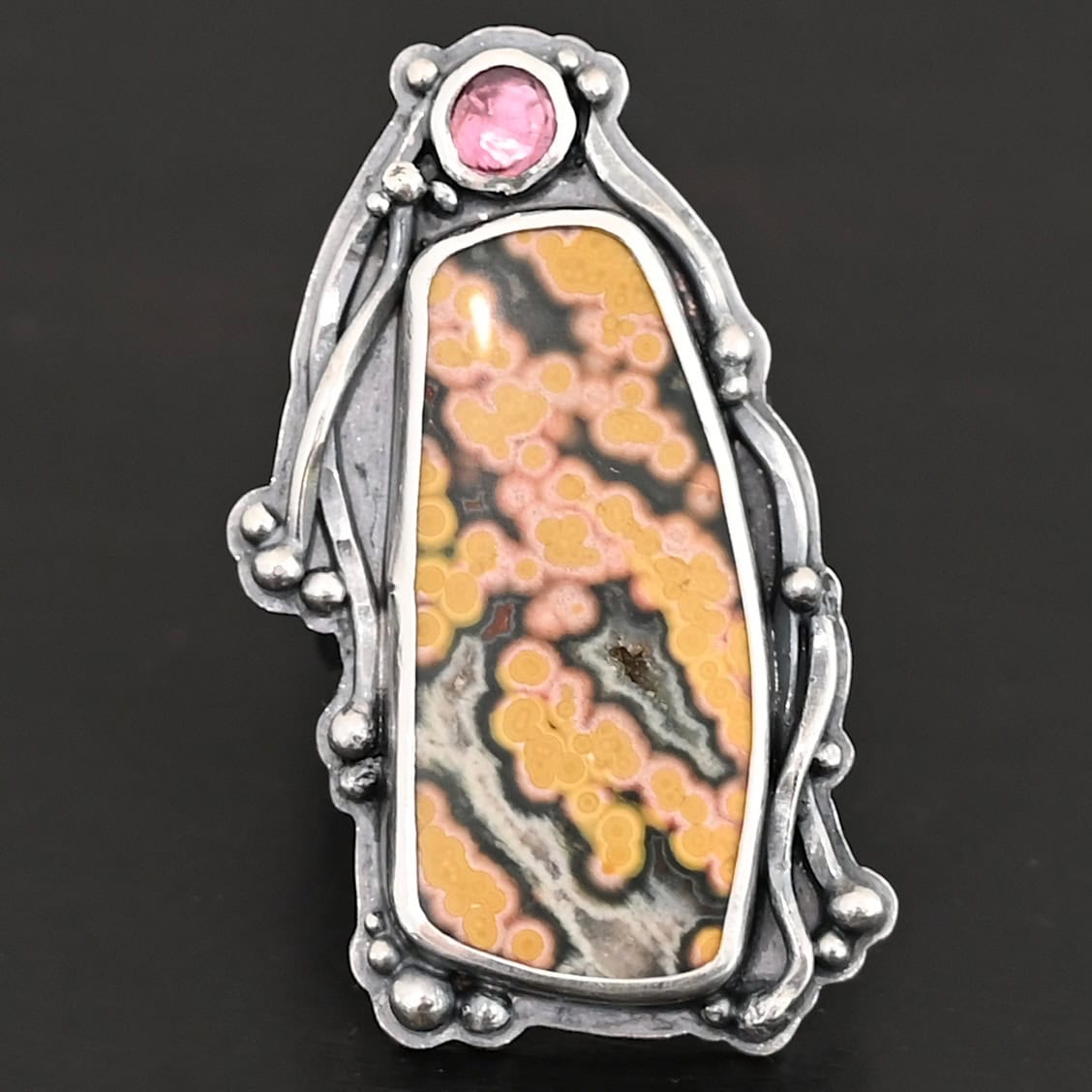 Yellow Rose Of Texas Ring "Yellow Rose Of Texas" Ring. There is a rectangular ocean jasper, set vertically. There is a smaller circular pink tourmaline above it. There are lots of wavy, hammered lines of silver around the stones.