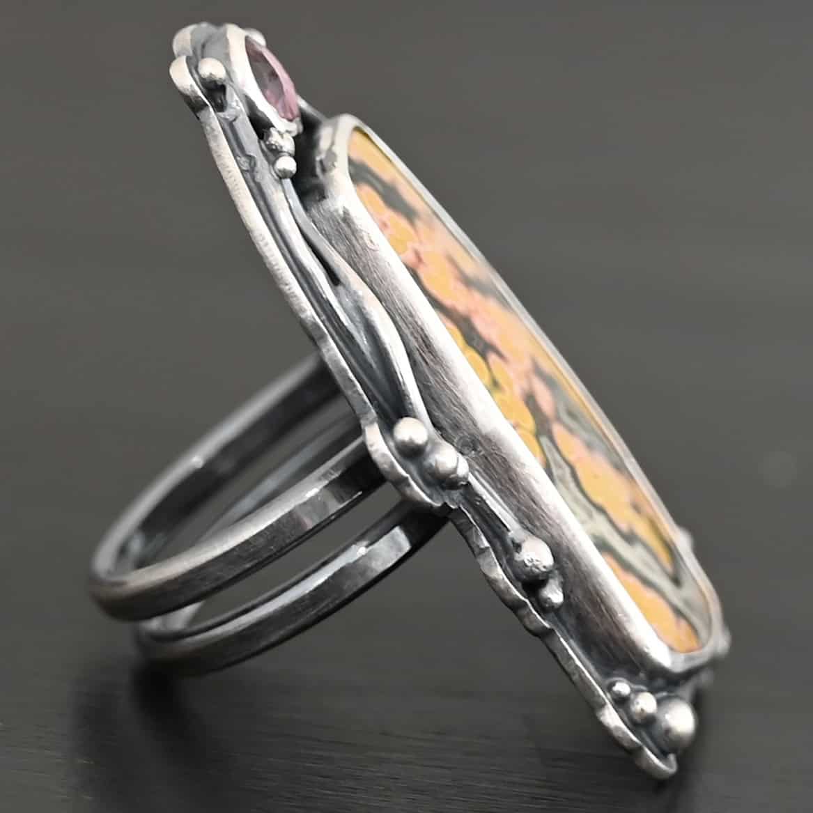 Yellow Rose Of Texas Ring "Yellow Rose Of Texas" Ring. There is a rectangular ocean jasper, set vertically. There is a smaller circular pink tourmaline above it. There are lots of wavy, hammered lines of silver around the stones. Ring is double banded so it can be adjusted.