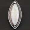"Artemis Ring" The ring is large, marquise, vertical moonstone. There is a ball of silver on the top and bottom of it. There is textured silver around it, and a thin layer around that which is hammered.