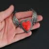 Heart On Fire Bracelet new "Heart On Fire" Bracelet. The bracelet is a rosarita heart with medium sized angel wings on each side. The angel wings curve lightly so they can fit around the wrist. There is two layers of hammered sterling silver around the heart. Bracelet has a silver lobster claw clasp. Bracelet is shown up close in the fingertips of a hand.