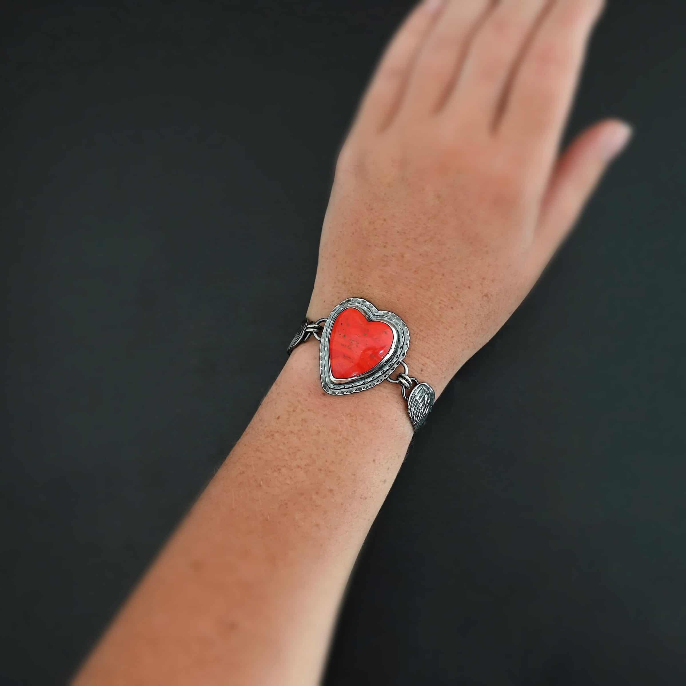 Heart On Fire Bracelet new "Heart On Fire" Bracelet. The bracelet is a rosarita heart with medium sized angel wings on each side. The angel wings curve lightly so they can fit around the wrist. There is two layers of hammered sterling silver around the heart. Bracelet has a silver lobster claw clasp. Bracelet is shown up close by a model.